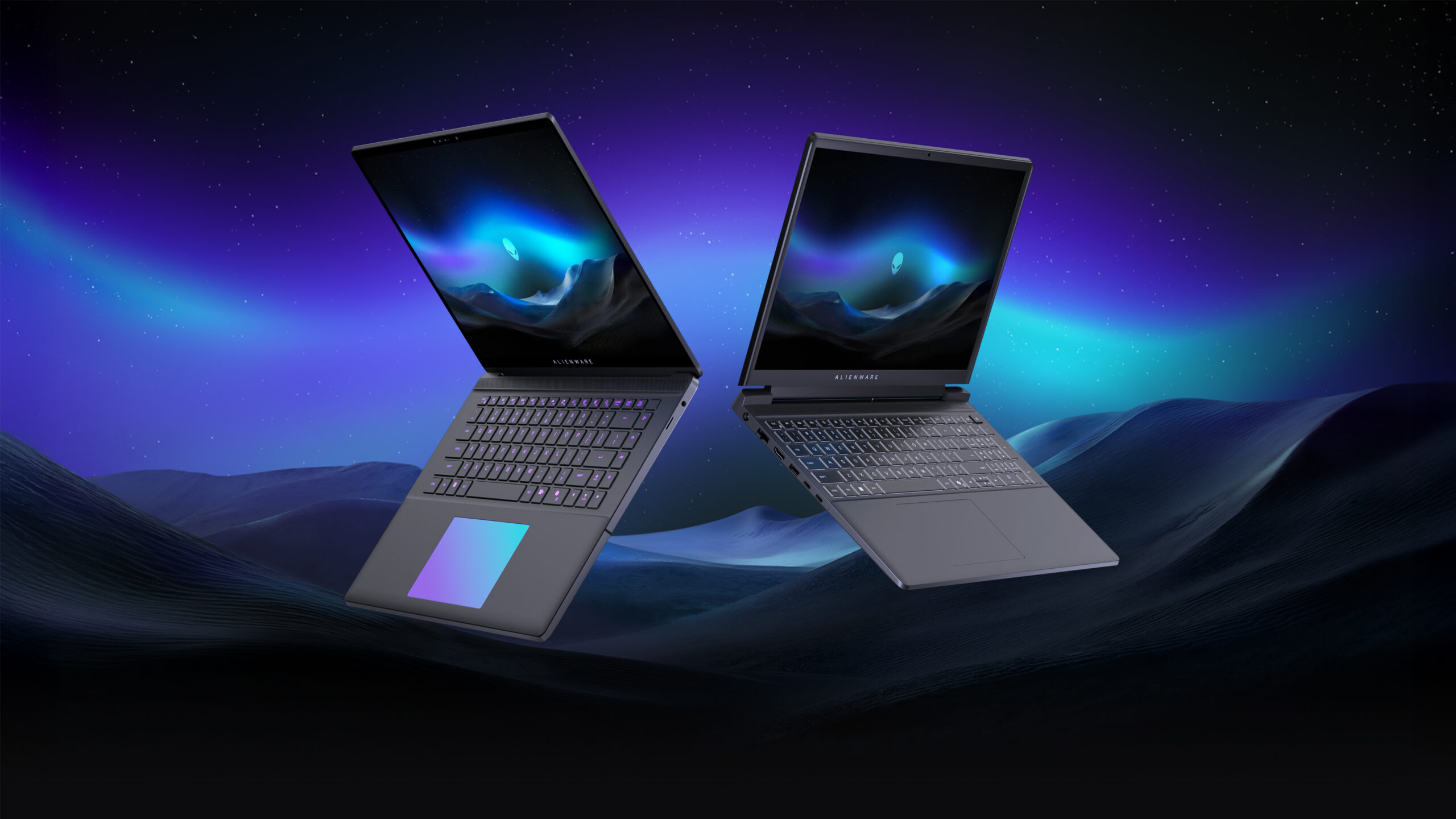 Renders of ultra-slim (left) and entry-level (right) Alienware laptops against a dark landscape illuminated by an aurora in the sky.