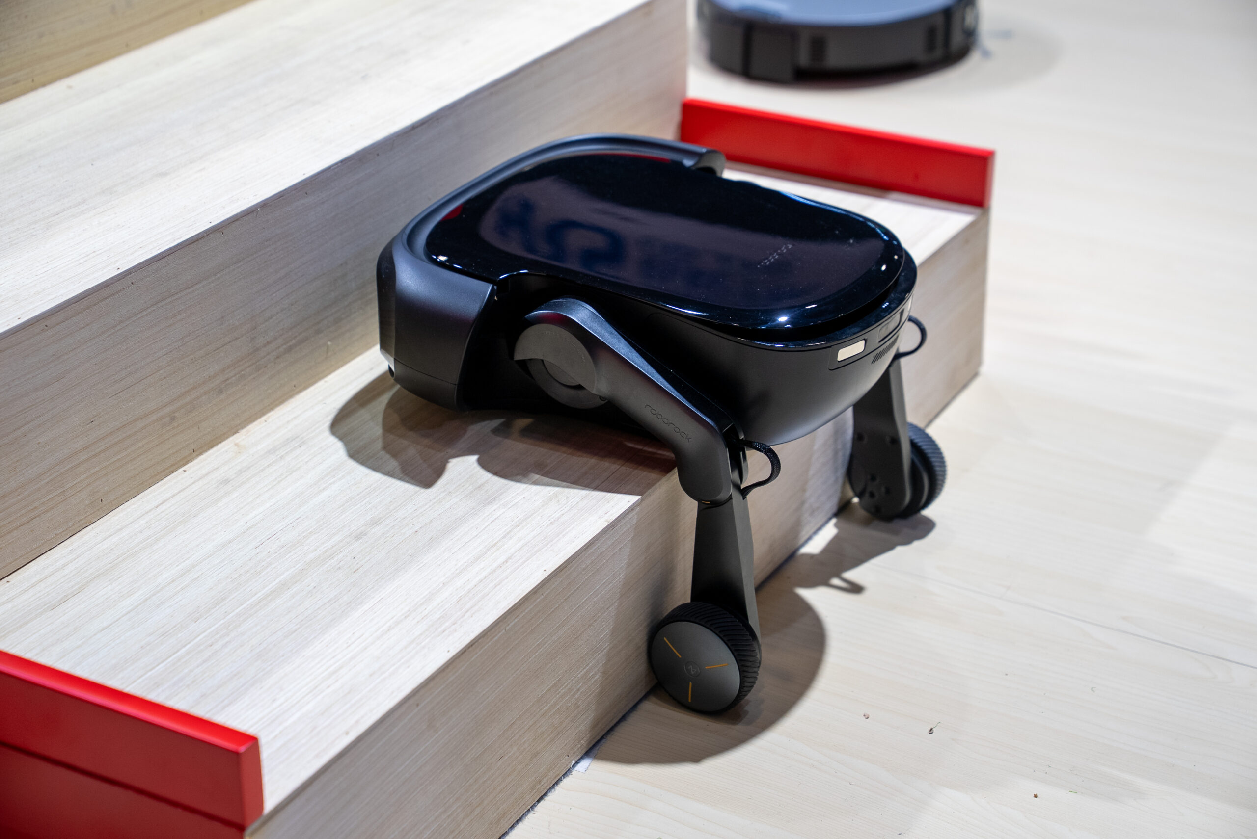 A robot vacuum on articulating legs with wheels.