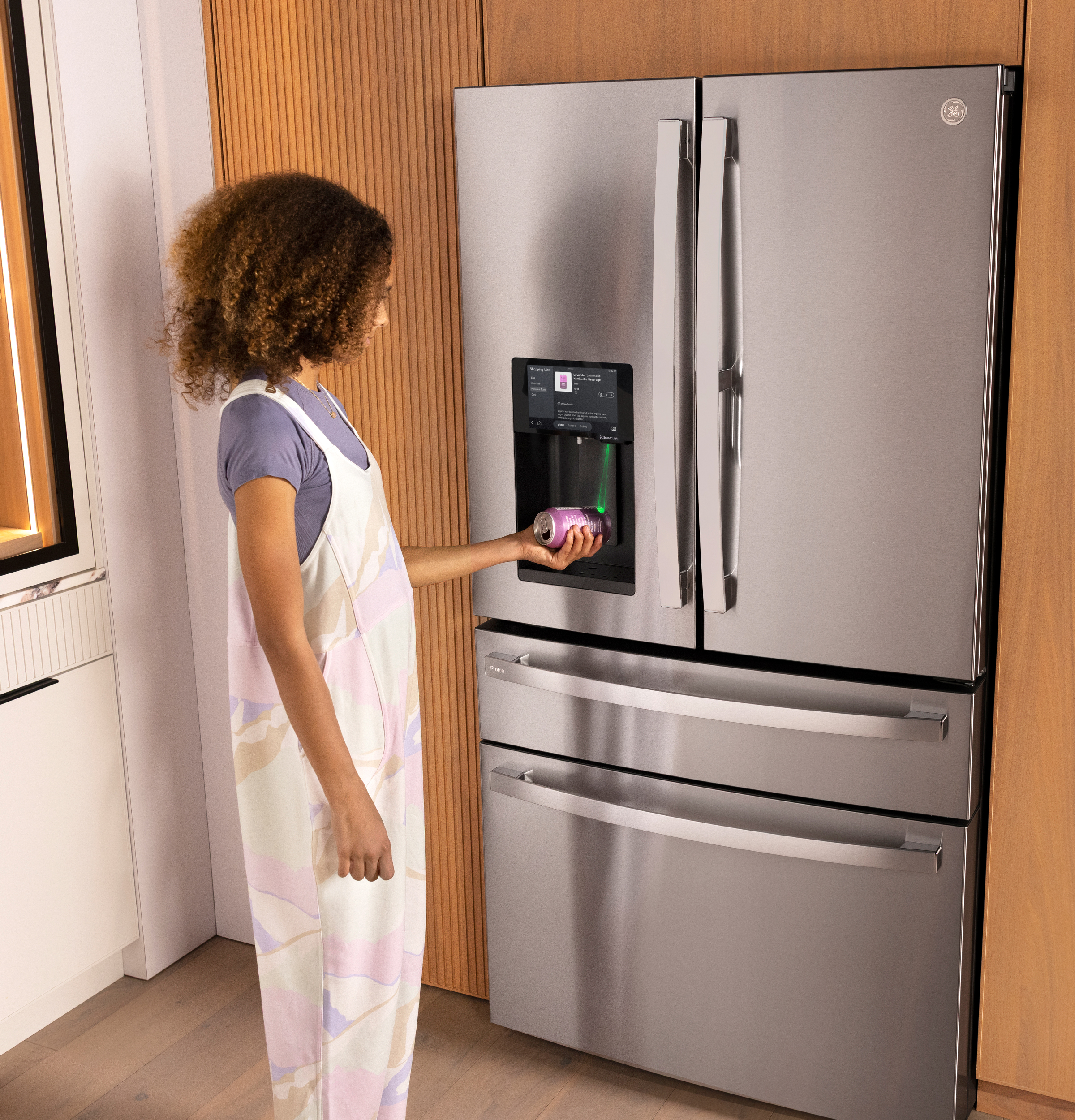 A woman standing in front of a fridge scanning an item.
