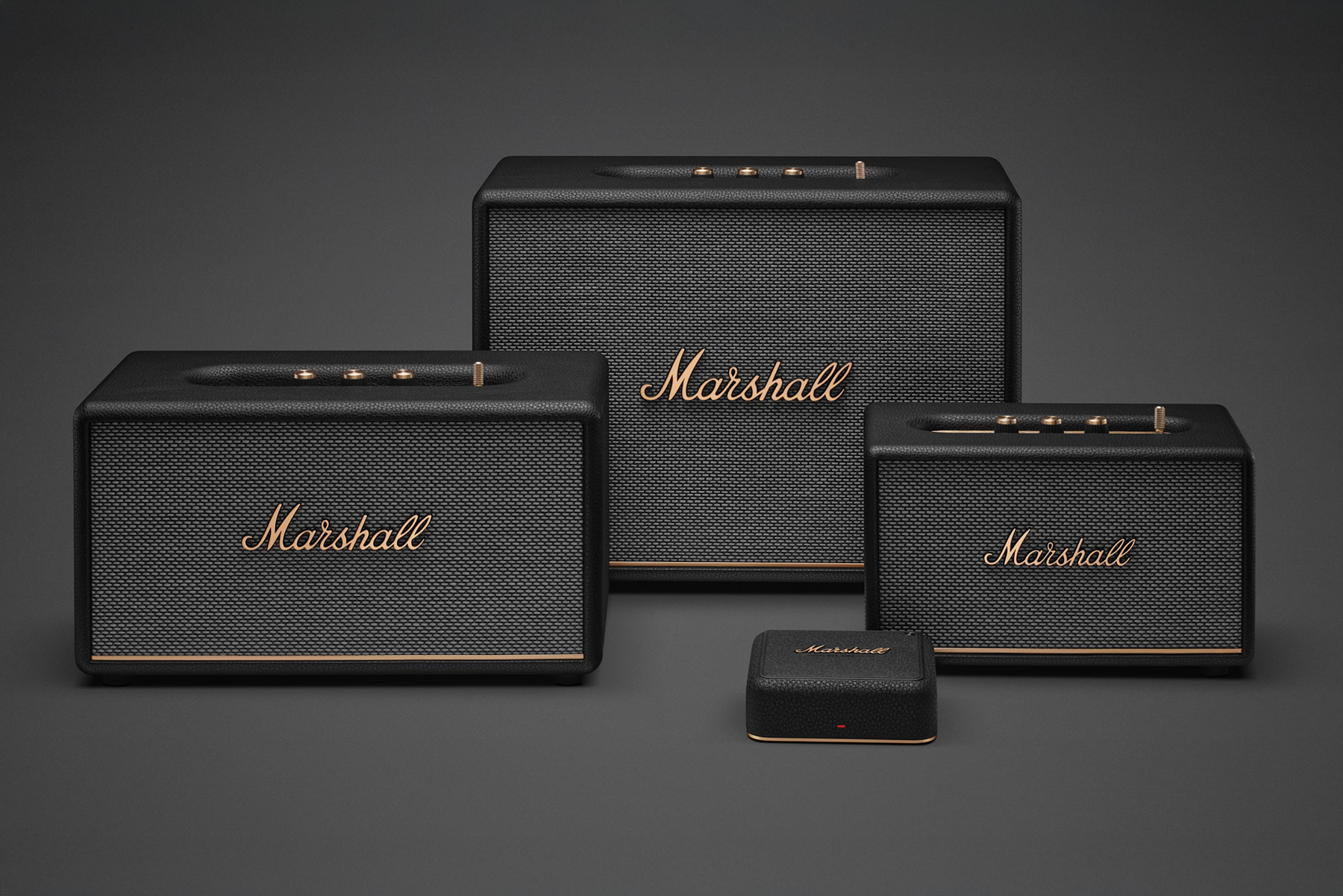 Marshall’s Heddon streaming hub next to three Bluetooth speakers.