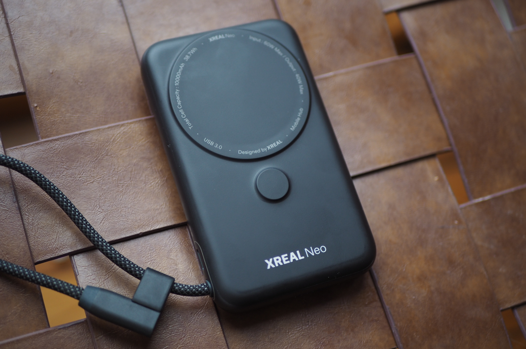 An image showing the Xreal Neo on a faux leather ottoman.