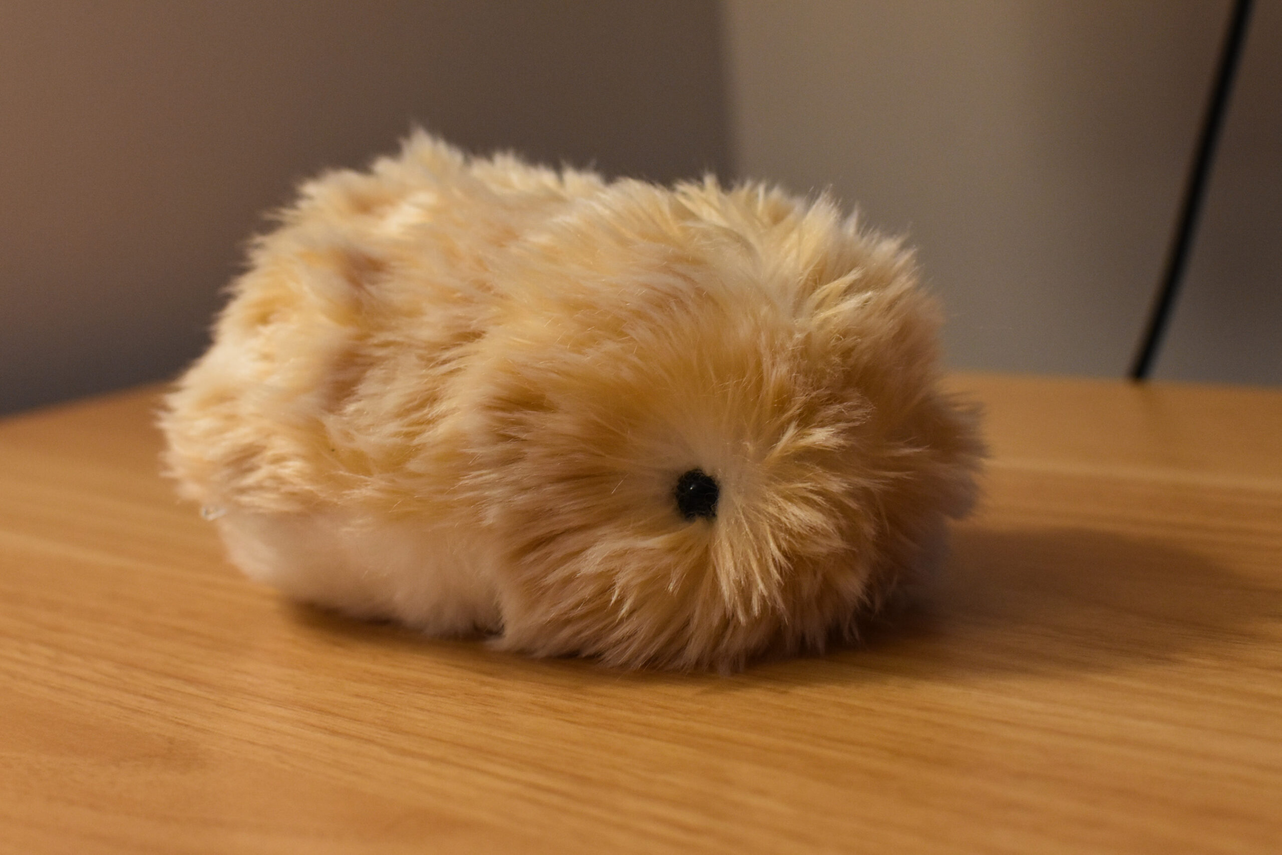 A bronze Moflin on a wooden desk.