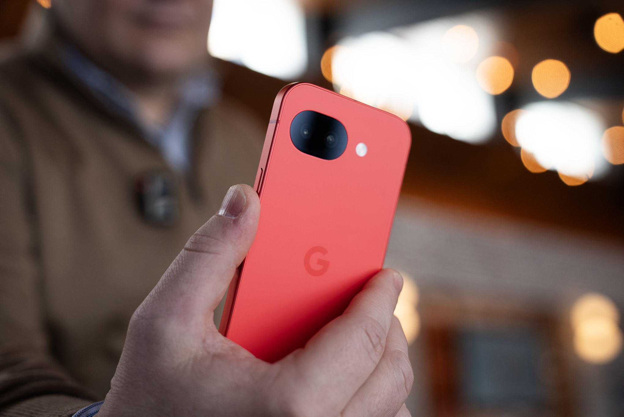 Rear shot of Google Pixel 10A in someone’s hand with camera lens and G logo visible.