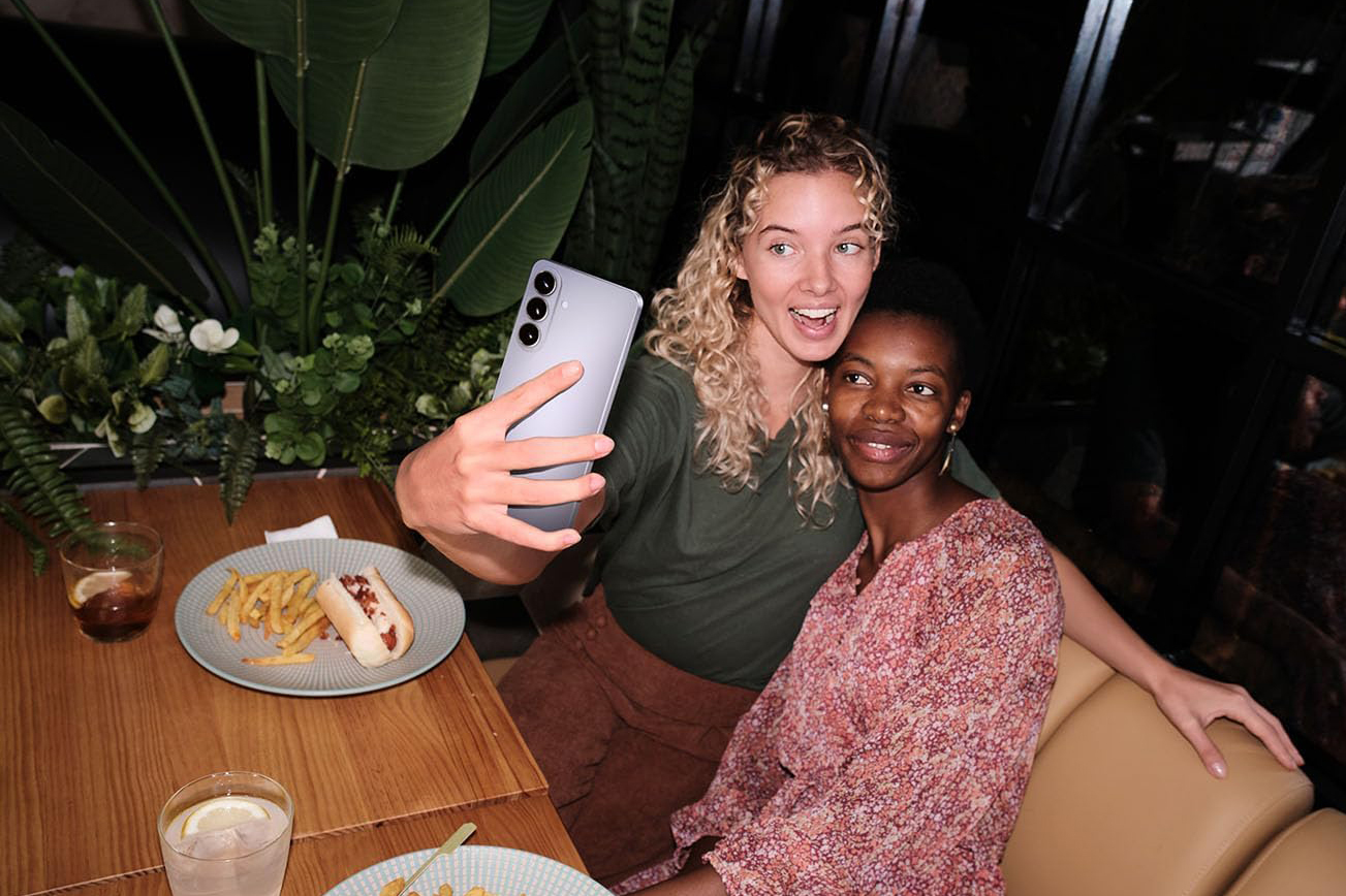 A person holding one of the Samsung Galaxy S26 phones.