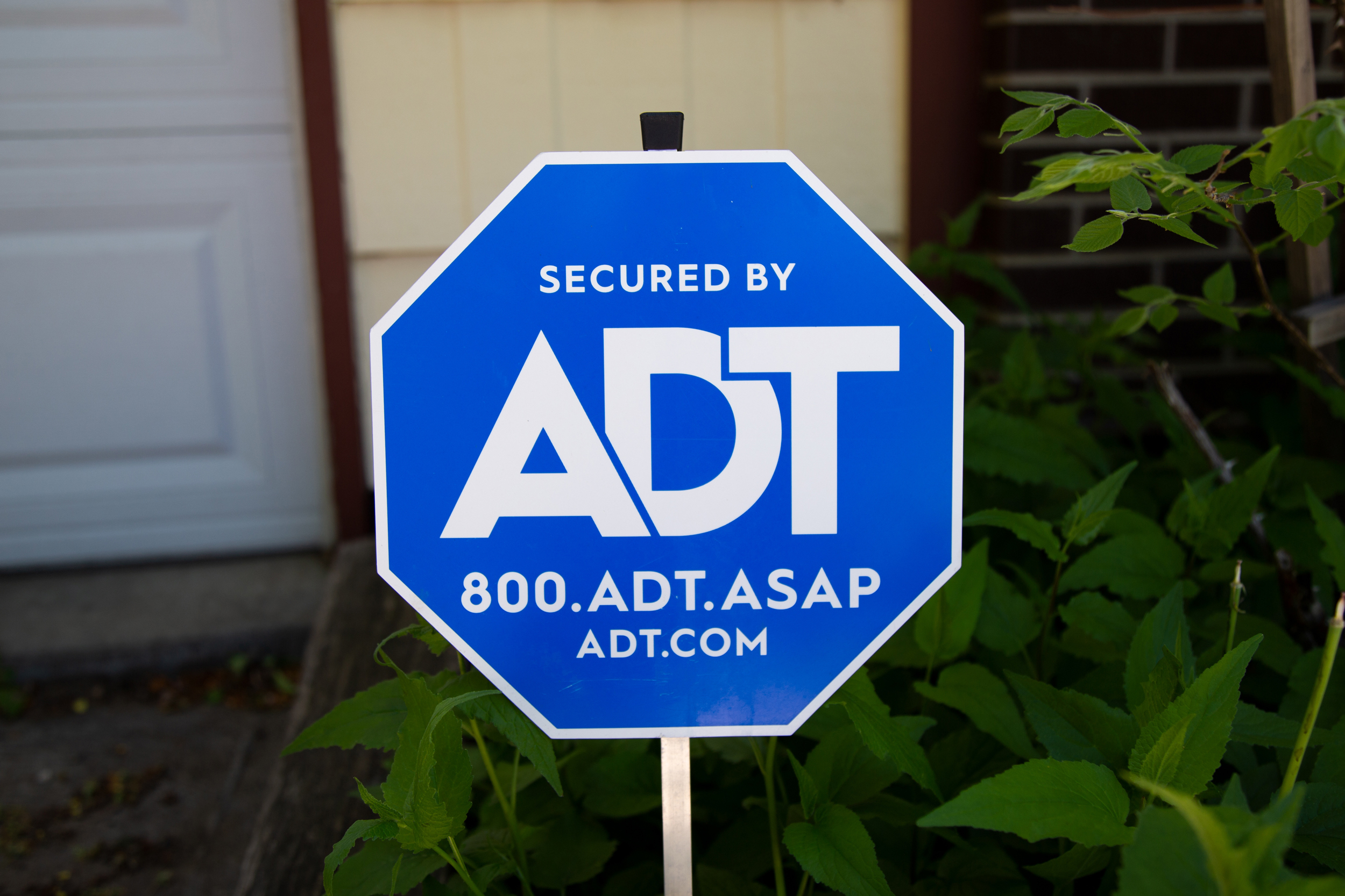 An ADT security sign in front of a house.