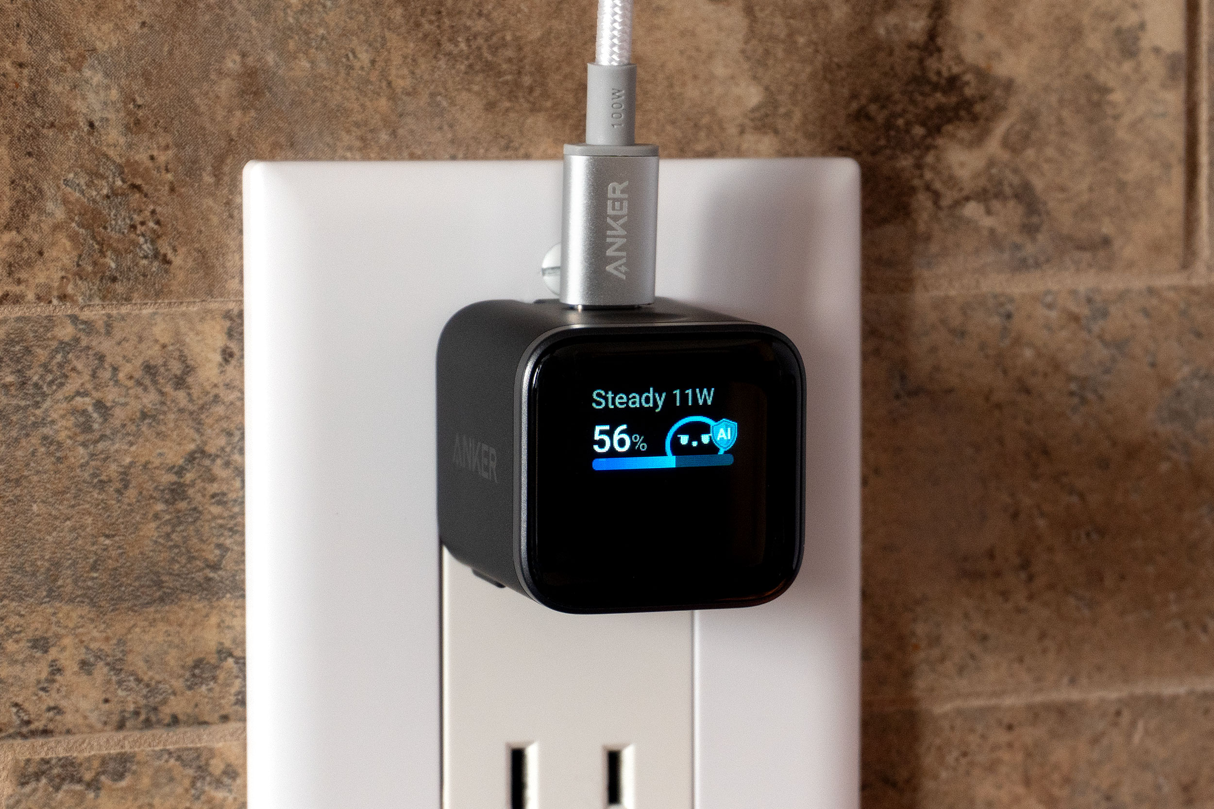 The Anker Nano charger plugged into a wall out with a USB-C cable attached.