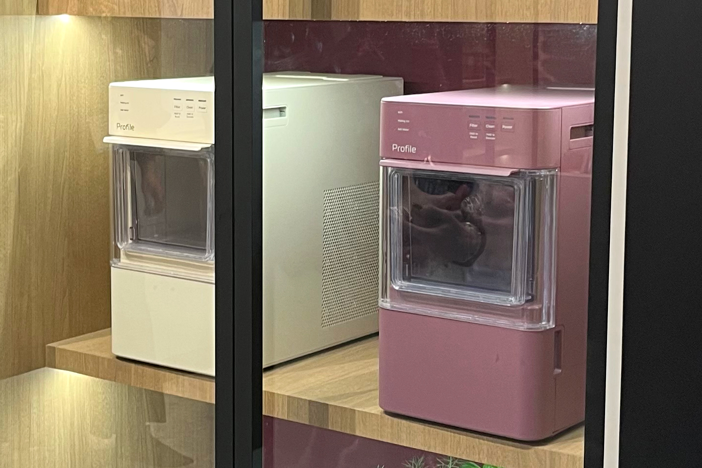 Two prototypes of the GE Profile Opal Mini nugget ice maker at a trade show booth.