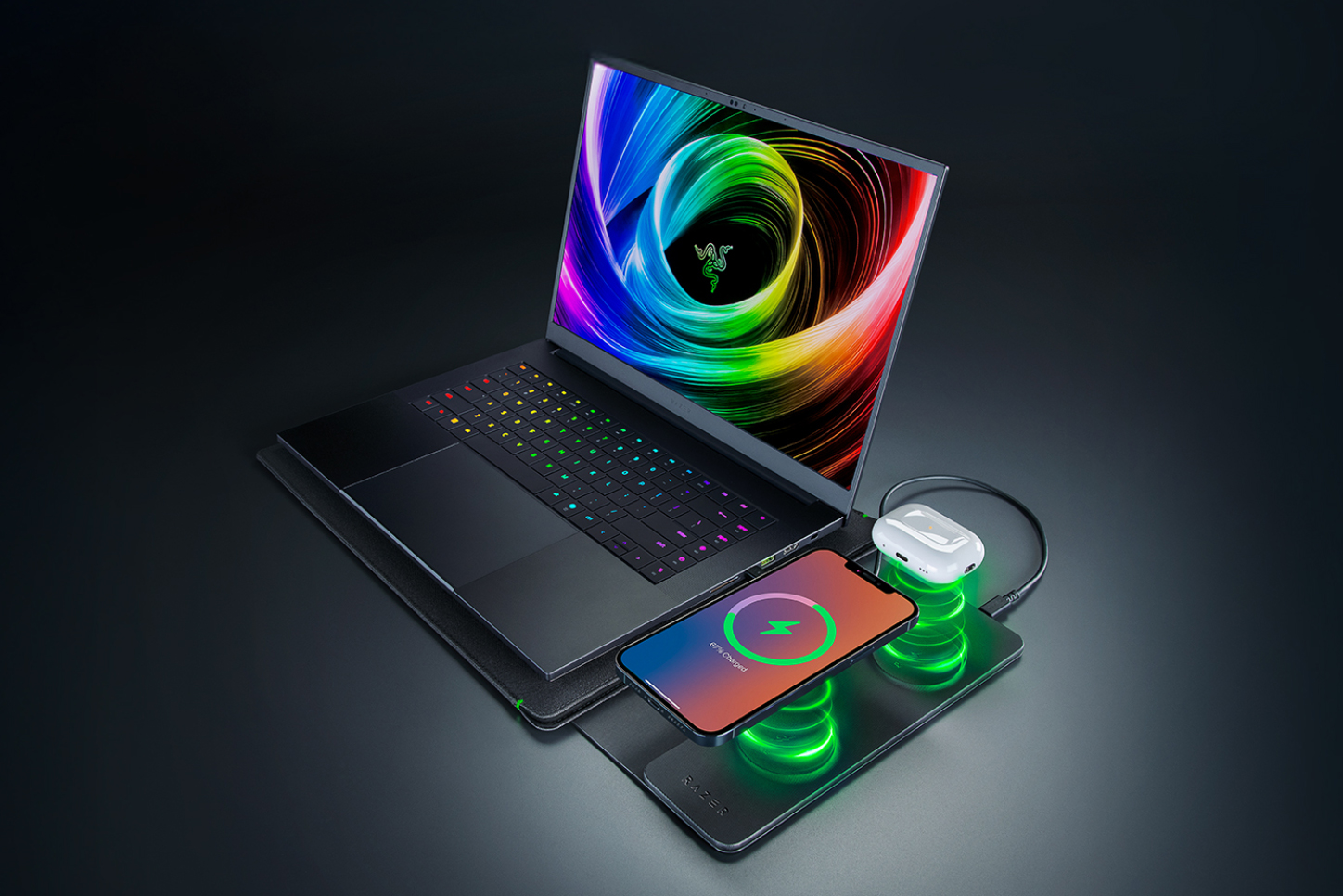 A smartphone and wireless earbuds being placed on the wireless charging pad of Razer’s new laptop sleeve.