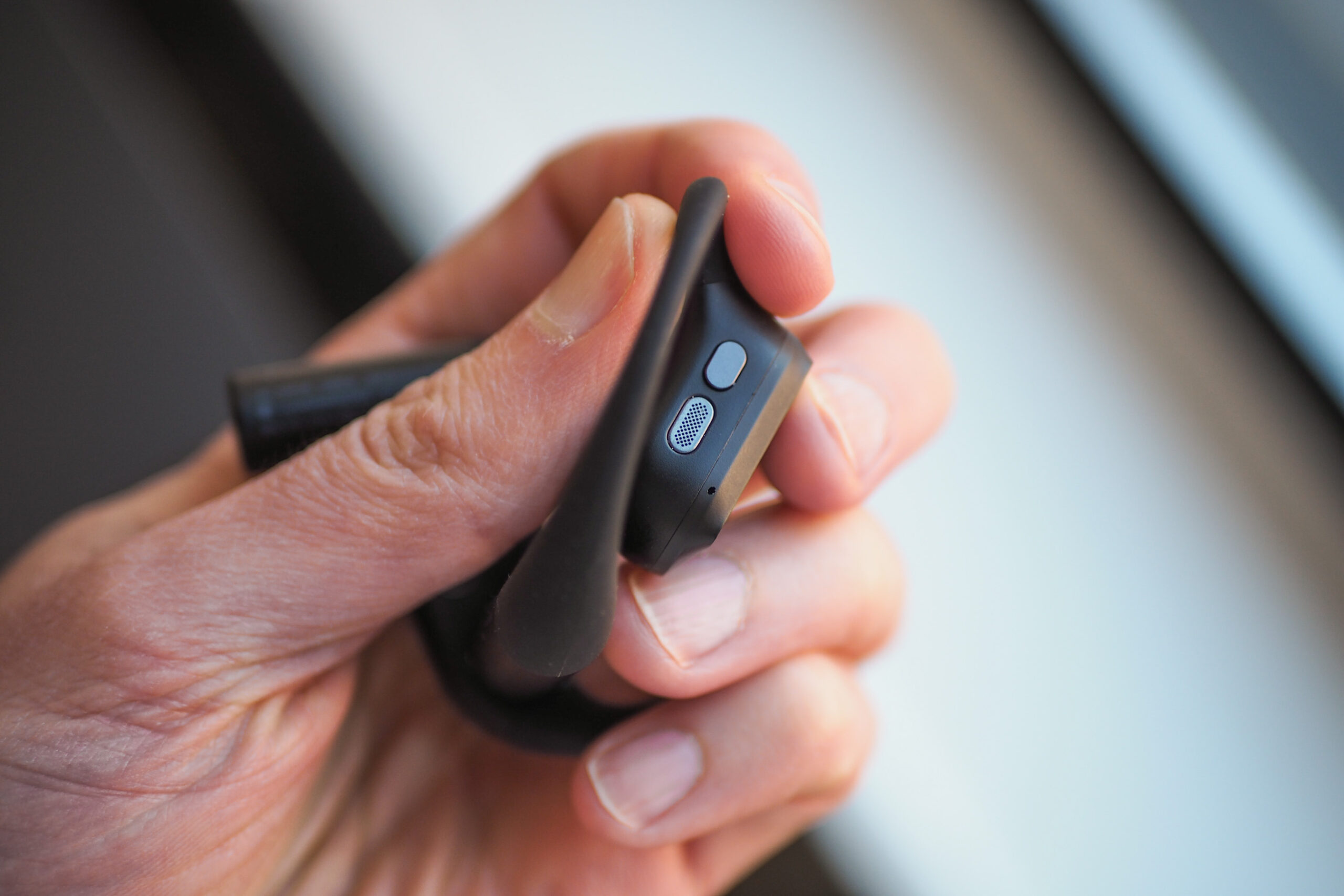 An image that shows a person holding one of the Asus Cetra Open Wireless earbuds in a way to show its top-mounted button. An image that shows a person holding one of the Asus Cetra Open Wireless earbuds in a way to show its top-mounted button.