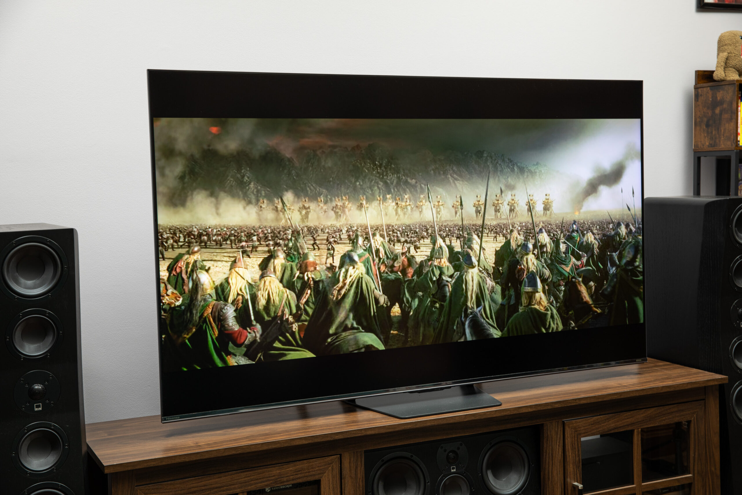 The Hisense U7SG displaying an image from Lord of the Rings on a wooden TV stand.
