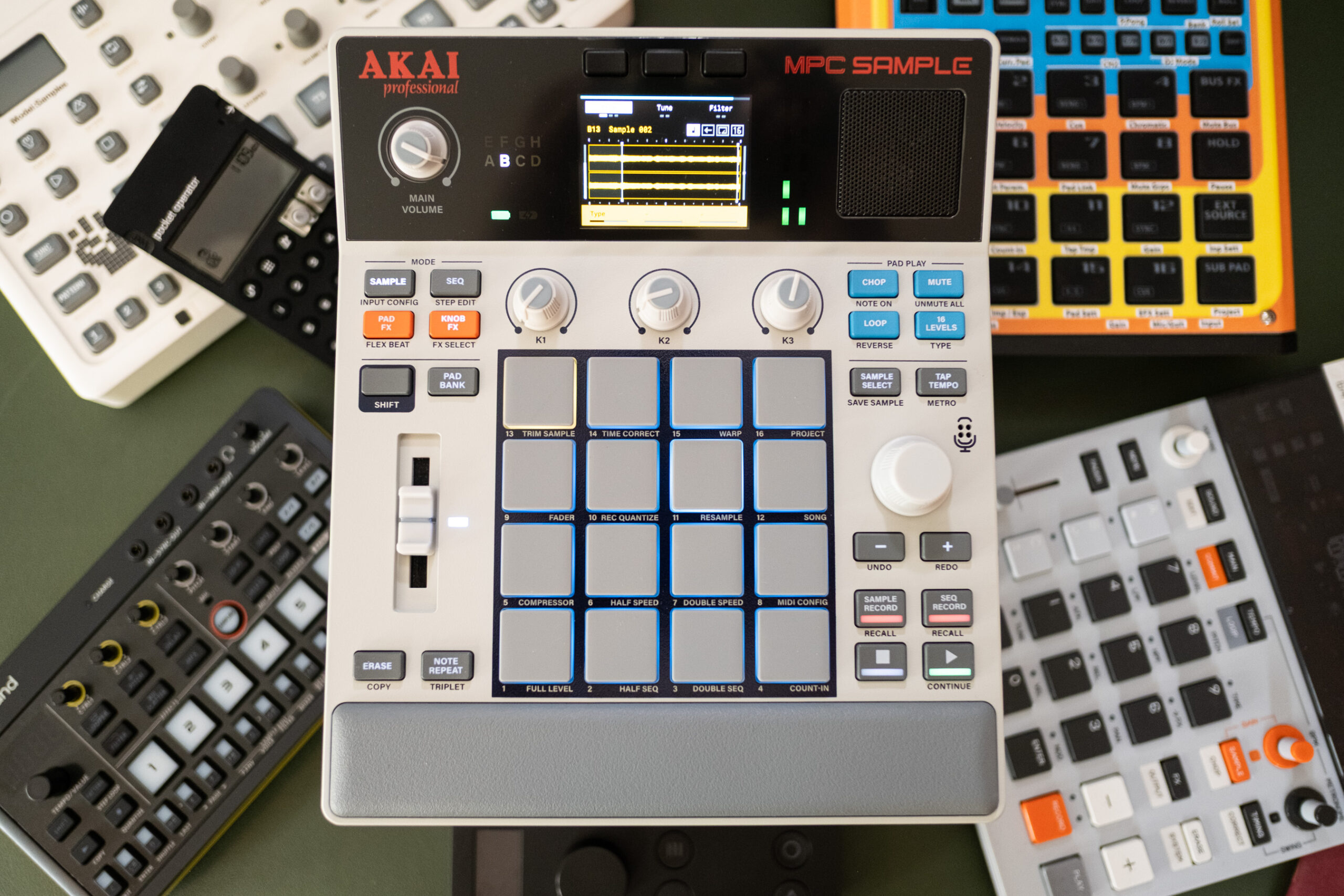 The MPC Sample, sitting on top of a collection of other small and battery-powered samplers.