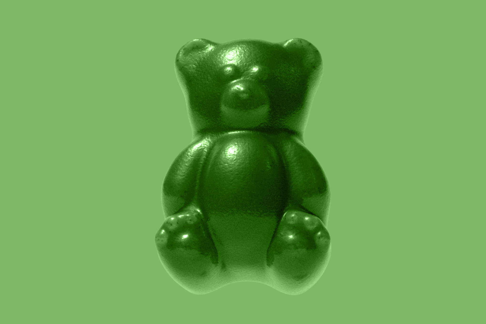 A large green gummy bear in front of a green background