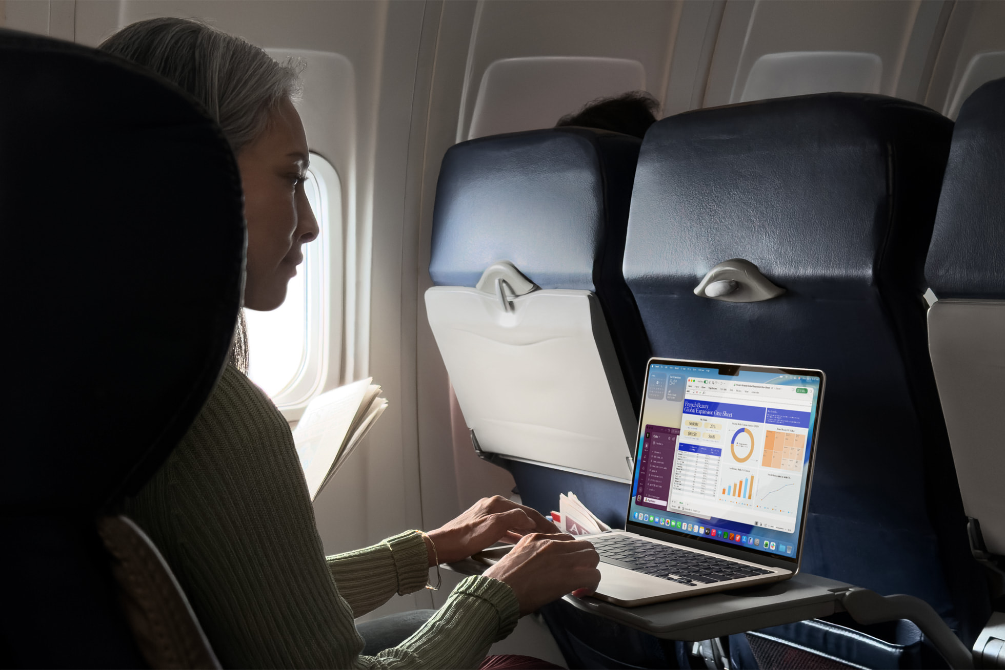 Person on a plane using a laptop.