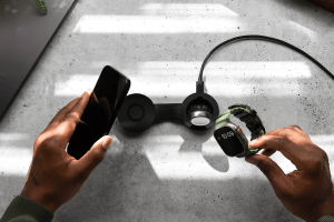 The Twelve South ButterFly SE 2-in-1 Qi2 Charger set up on a table with an iPhone and Apple Watch Ultra.