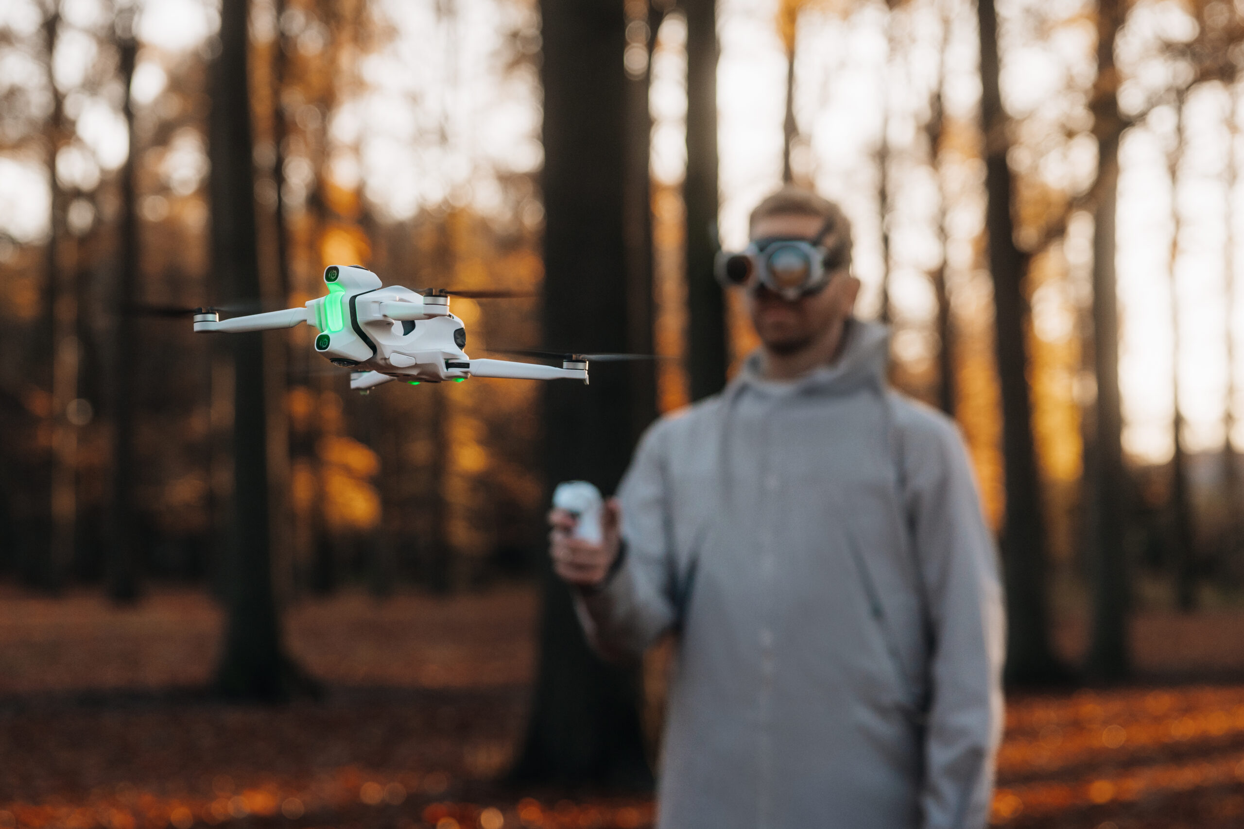 A person flying the Antigravity A1 drone, controlling it with its included remote control and viewing what its cameras see through the included Vision Goggles.