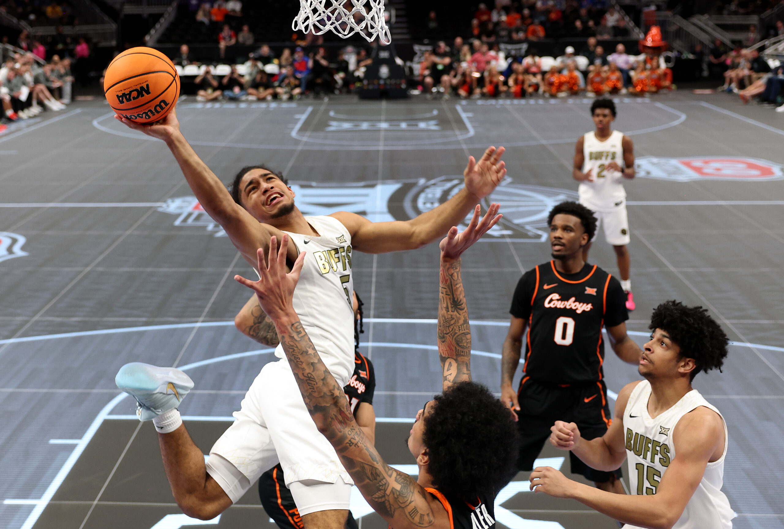 Josiah Sanders of the Colorado Buffaloes shoots as Vyctorius Miller of the Oklahoma State Cowboys defends during the first round game of the Men's 2026 Big 12 Tournament at T-Mobile Center.