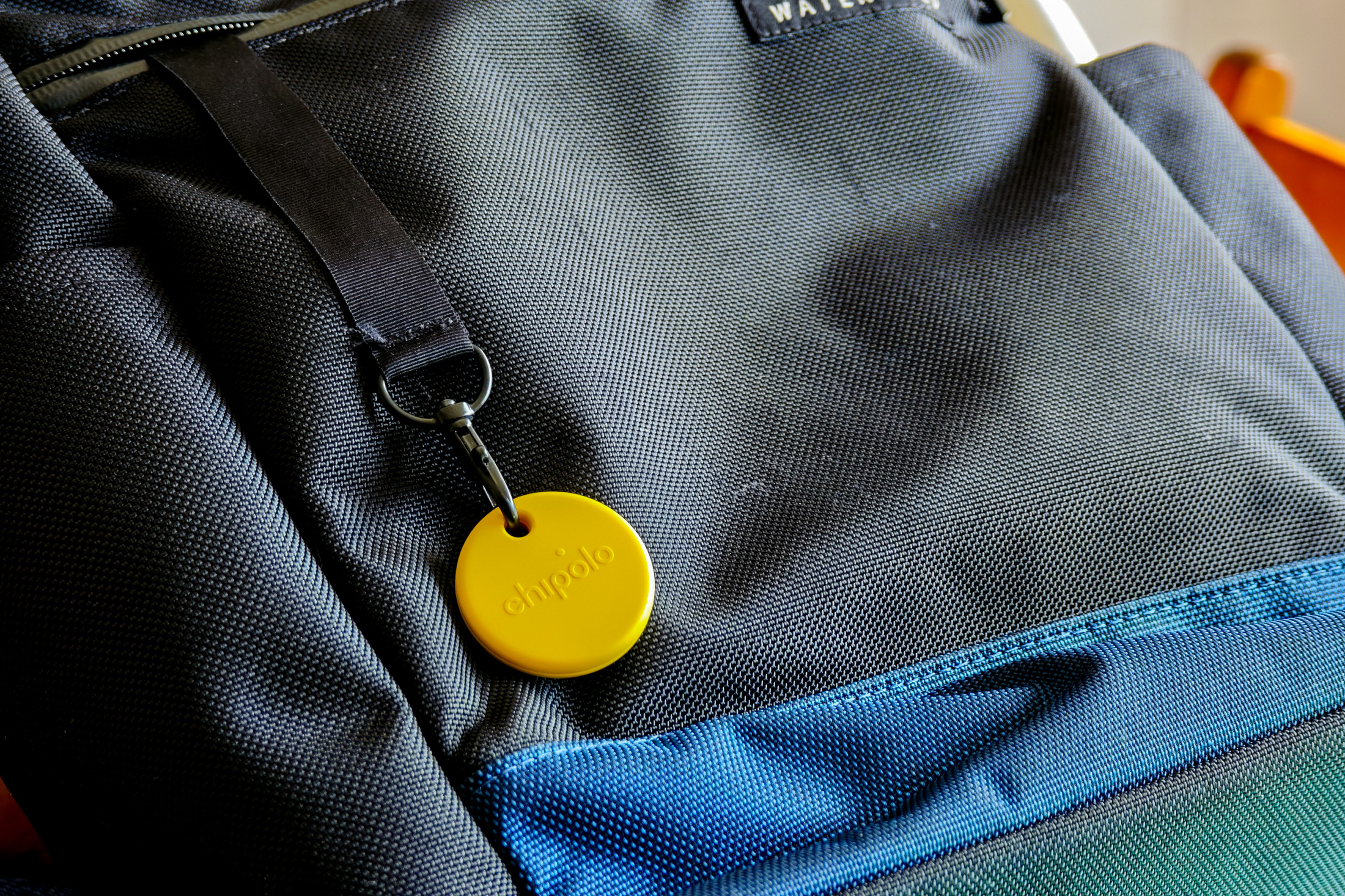 A Chipolo Pop tracker attached to a backpack