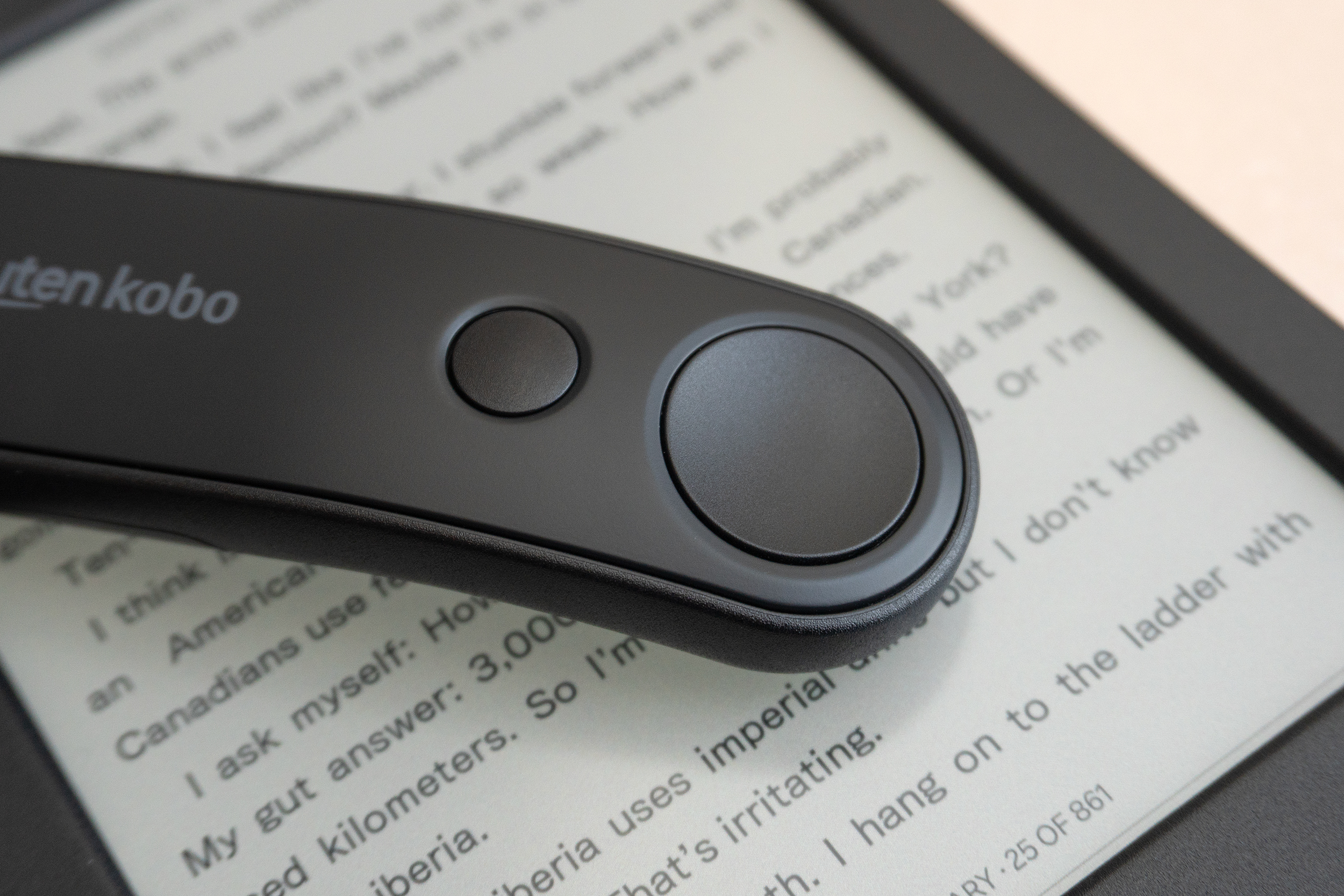 A close-up of the page turn buttons on top of the Kobo Remote sitting on a Kobo e-reader. A close-up of the page turn buttons on top of the Kobo Remote sitting on a Kobo e-reader.