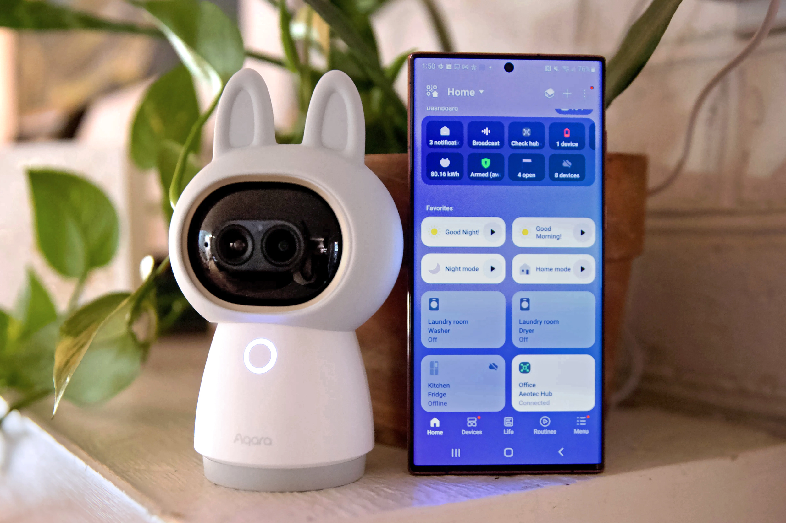 The Aqara G350 camera next to an Android smartphone.