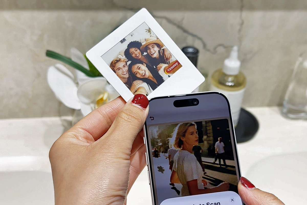 A VidaBay digital photo frame being synced with a phone’s NFC chip.