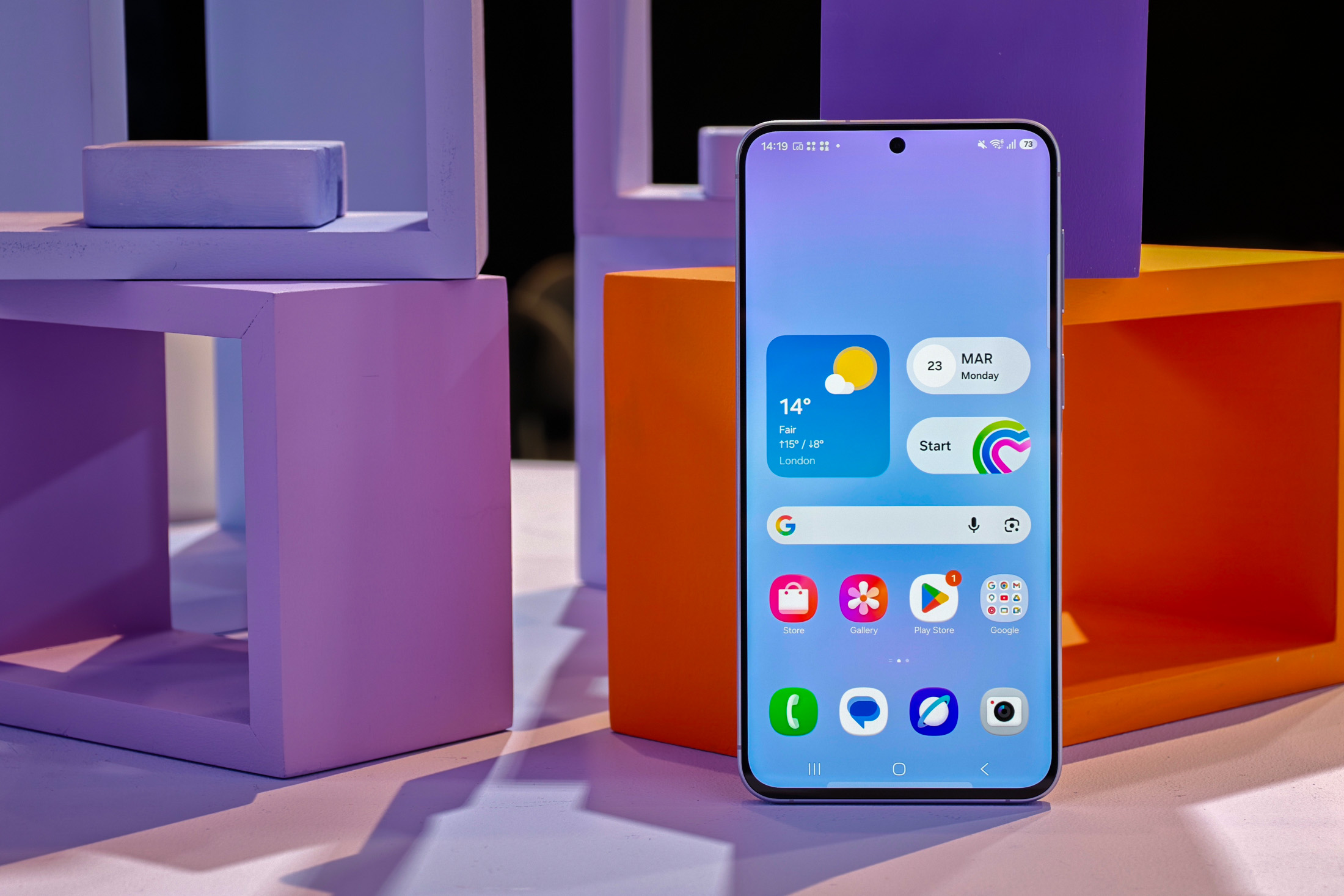 Samsung Galaxy A57 showing homescreen in front of colored cubes