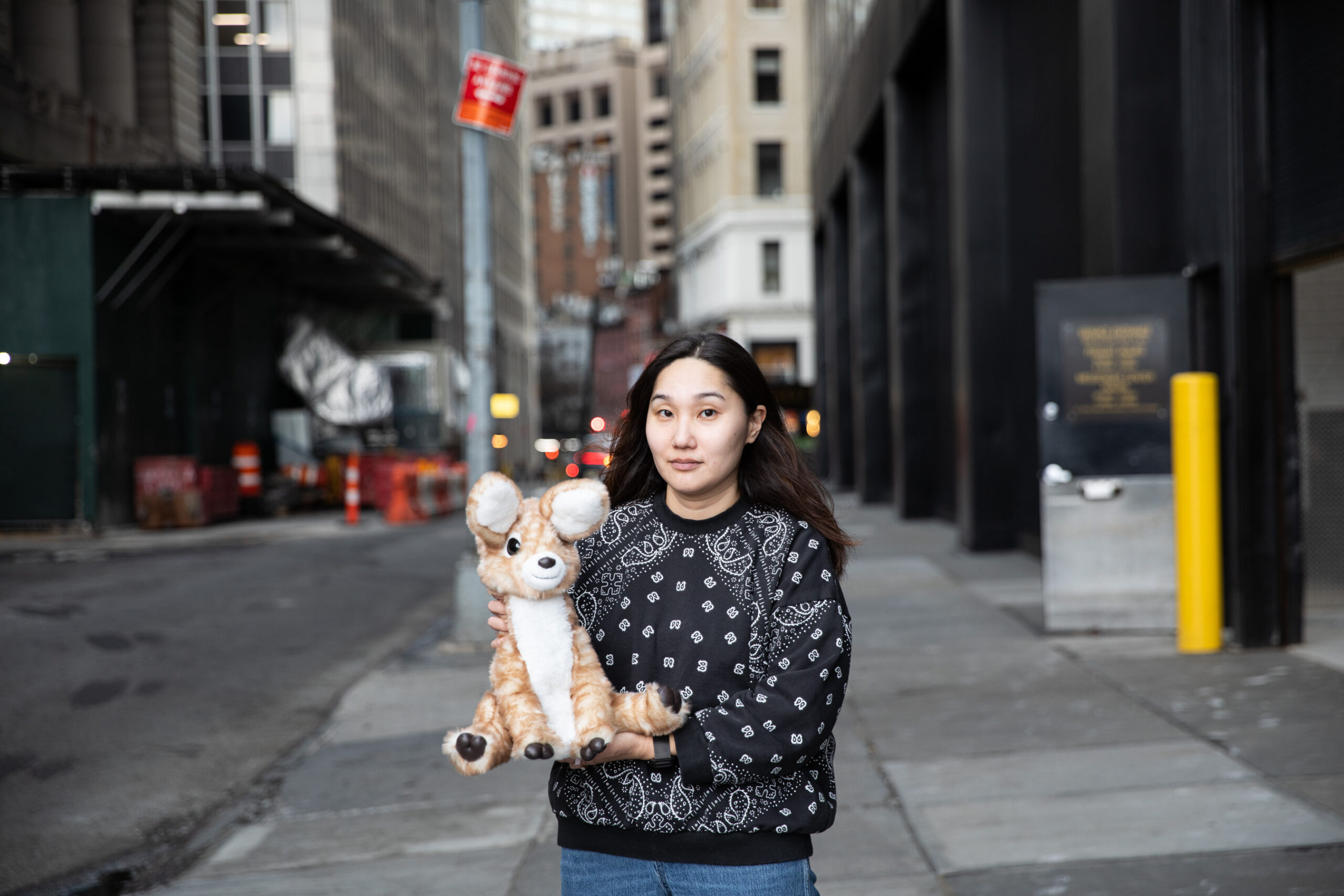 Senior reviewer Victoria Song stands on a street holding an AI plushie deer.