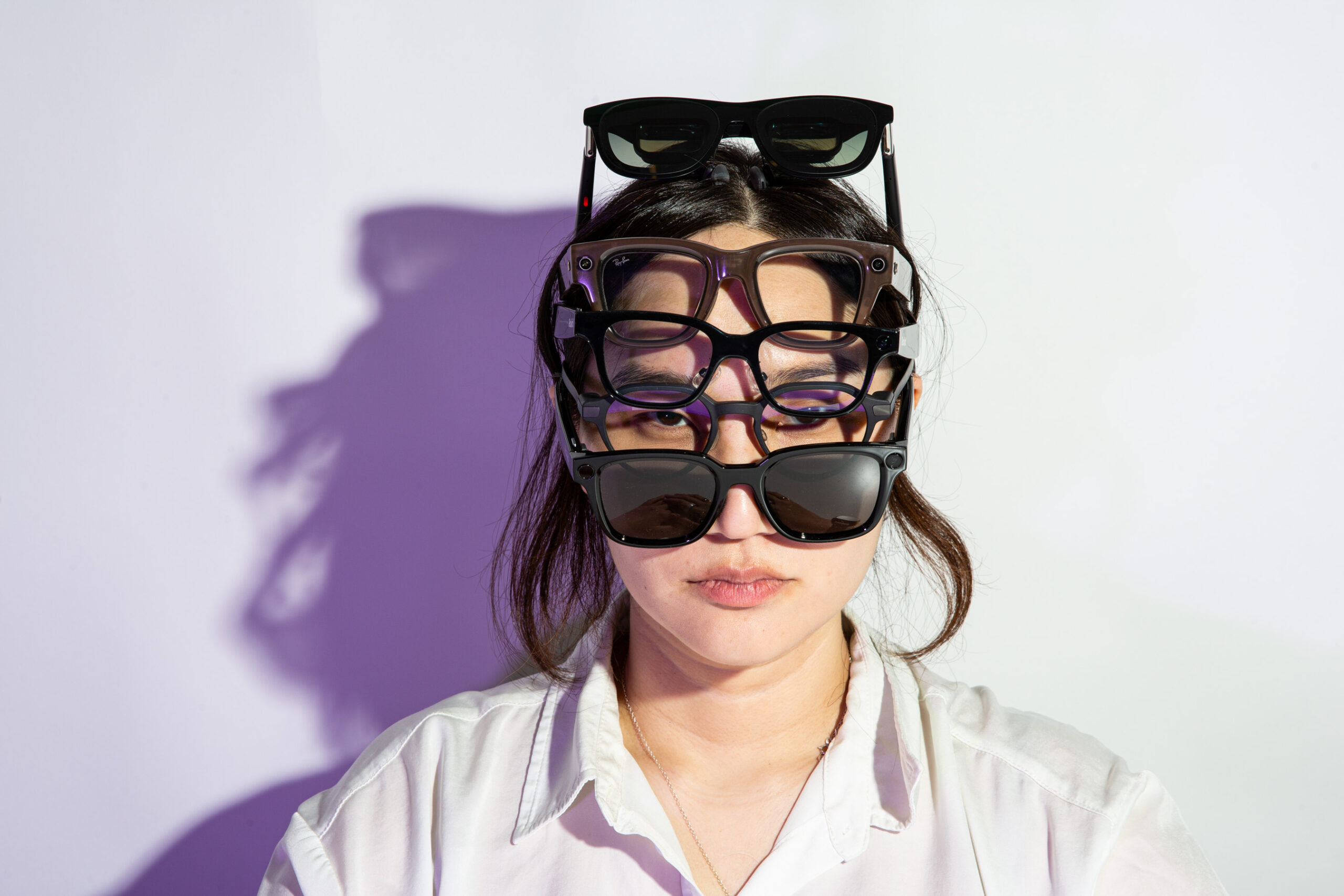 Senior Reviewer Victoria Song wearing five pairs of smart glasses at once.