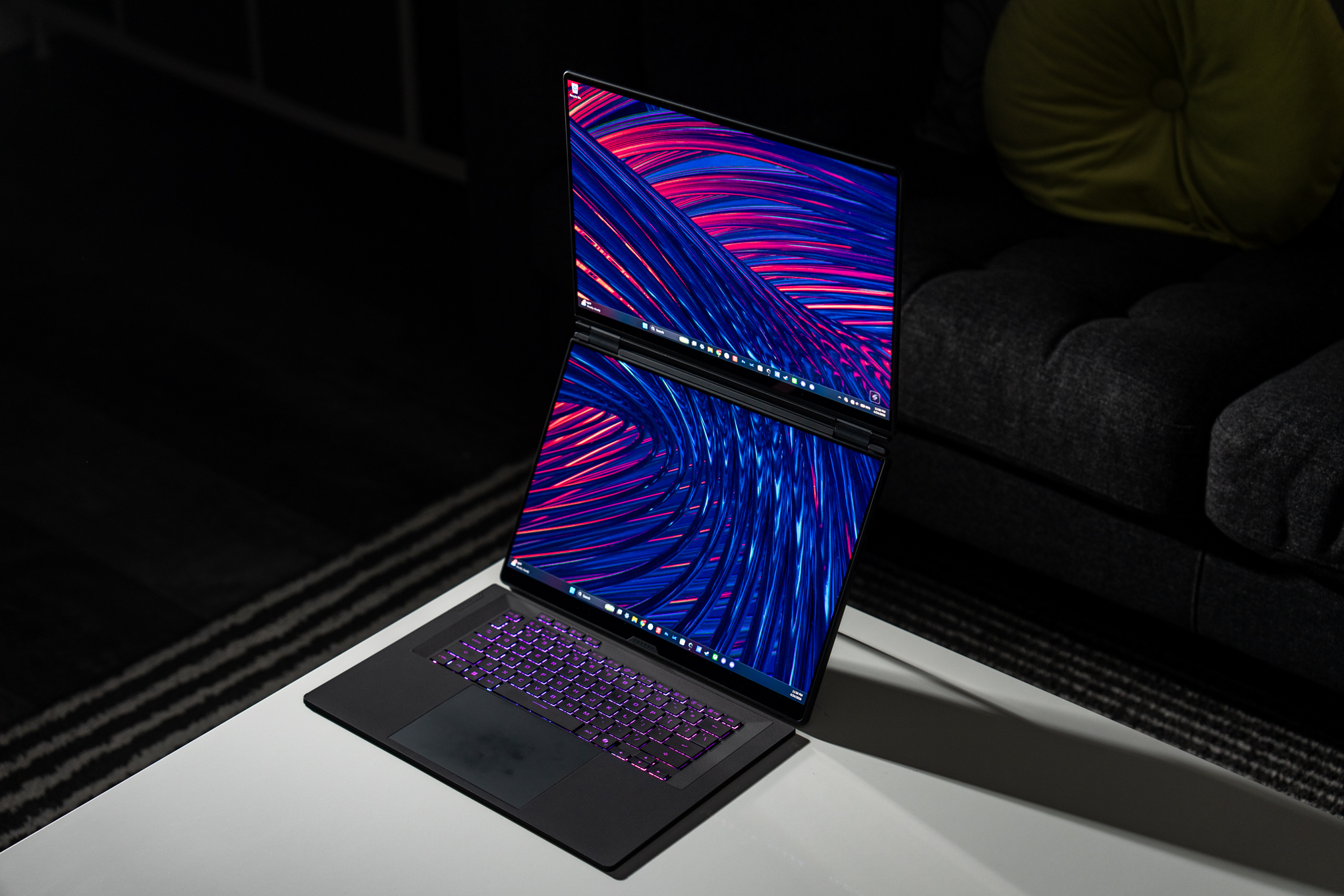 A dual-screen Asus ROG Zephyrus Duo gaming laptop on a white coffee table.