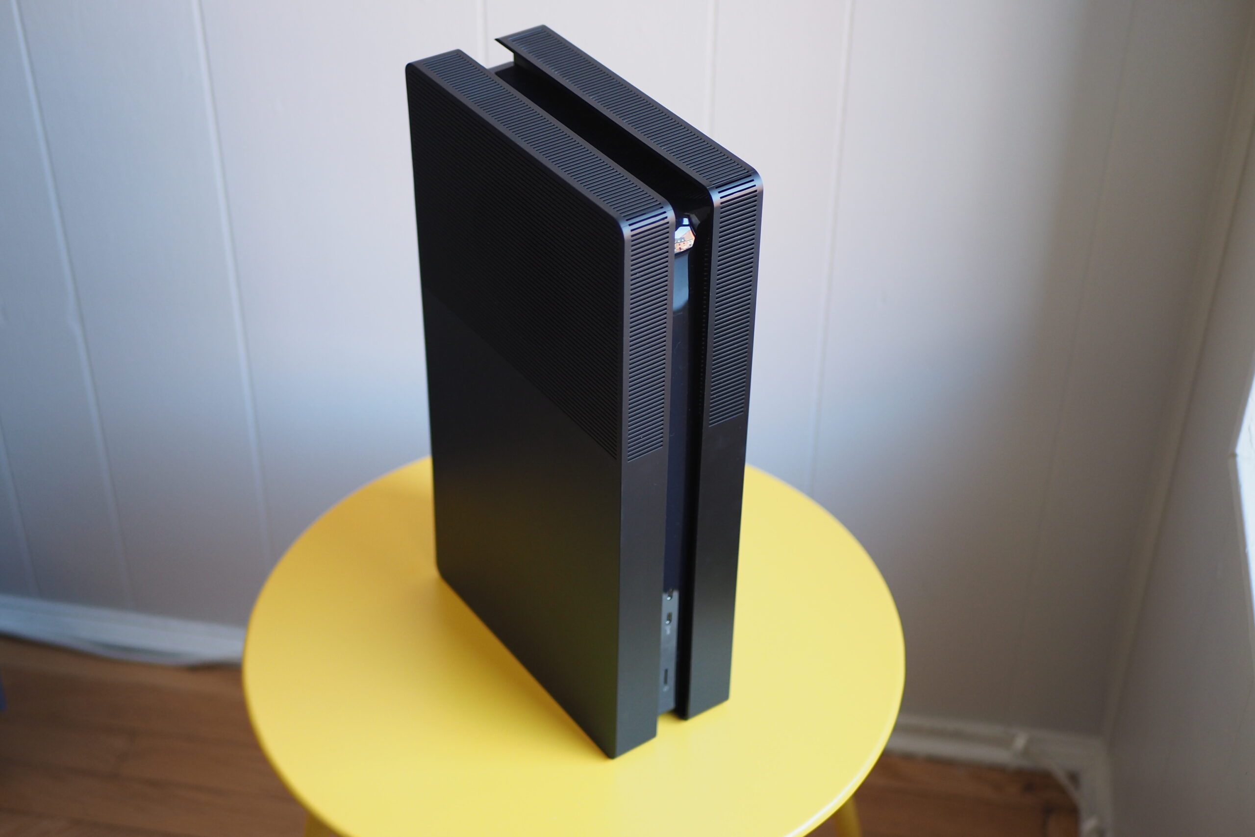 An image of a PlayStation 5 Pro console with BoxPlates attached, which change its appearance. The console is sitting on a yellow circular table.