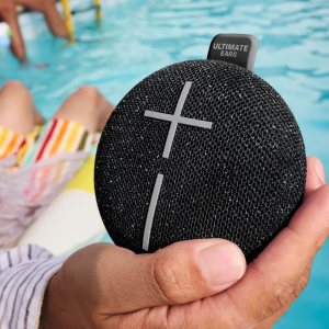 Someone holding the Ultimate Ears Miniroll by the pool.