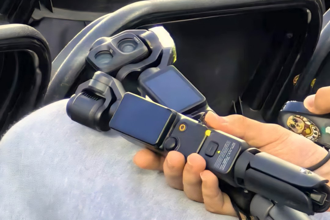 A person holds two stabilized cameras in their hand.