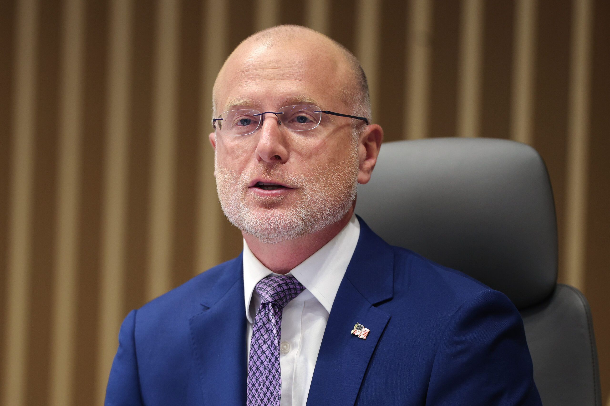 FCC Chairman Brendan Carr speaking to a group of people while sitting in a chair.