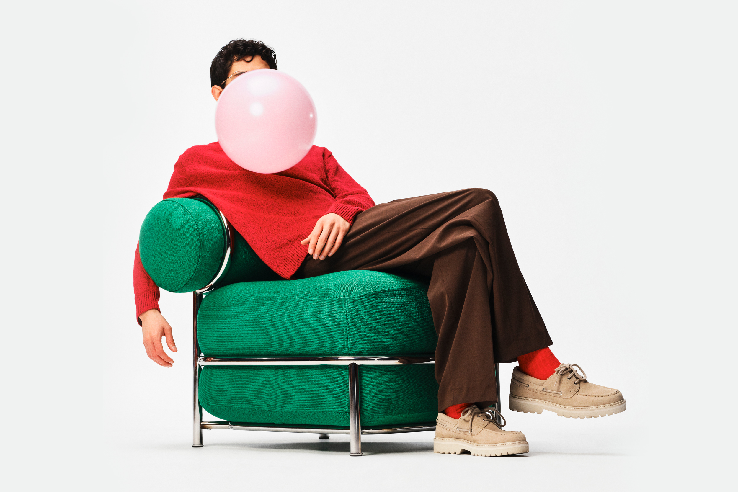 A person sits in an inflatable green chair designed by Ikea.