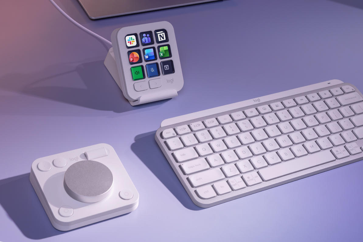 A desk with a Logitech MX keyboard and Creative Console displaying shortcuts for several productivity apps.