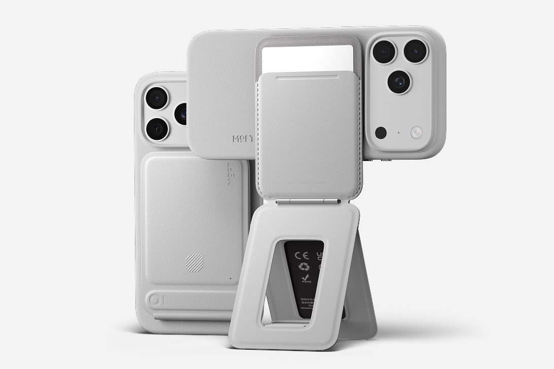 The Moft Trackable Tripod Wallet shown attached to a smartphone and unfolded into a stand.