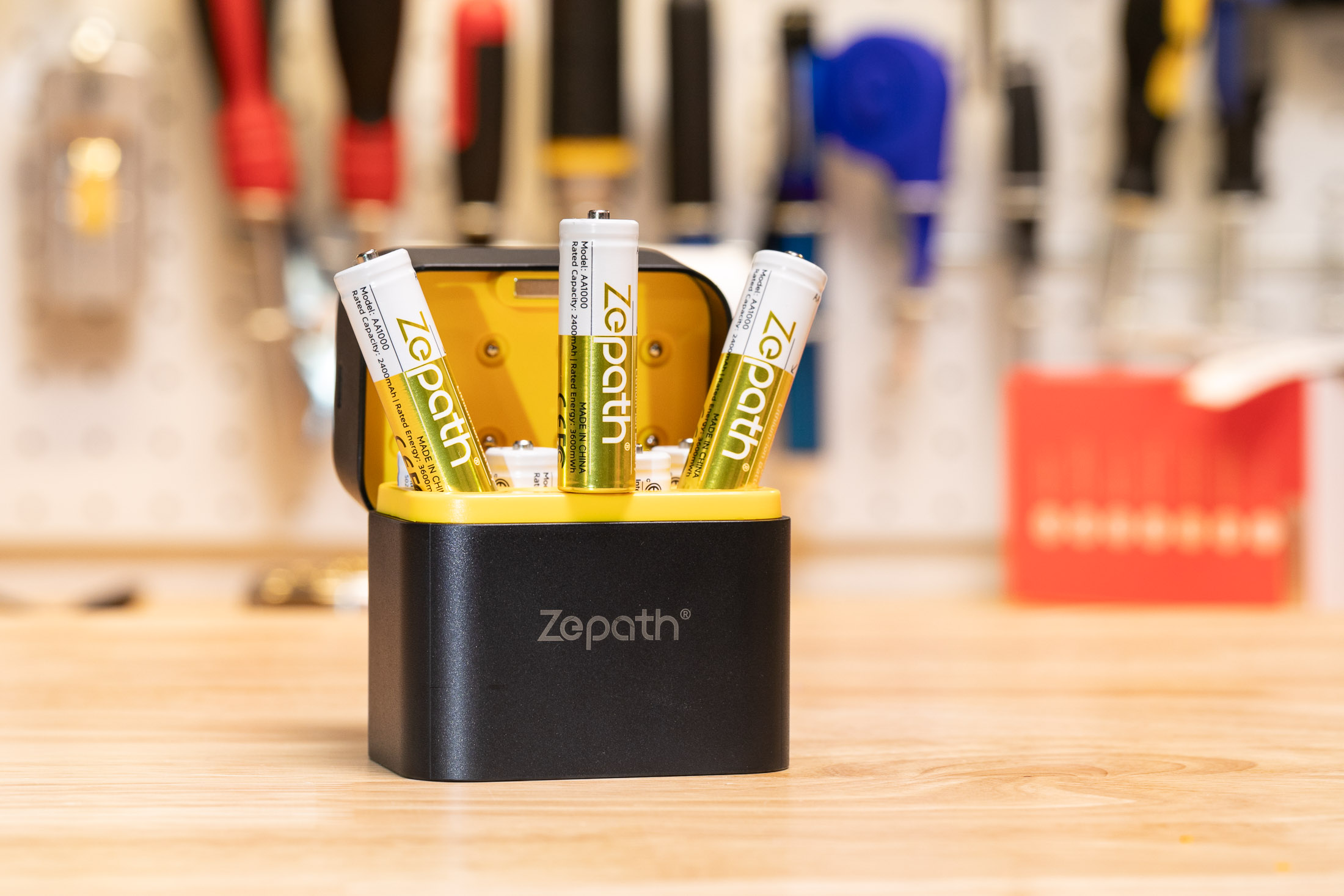 Three Zepath AA batteries stick out of its clamshell charging case, sitting on Sean’s bamboo worktop.