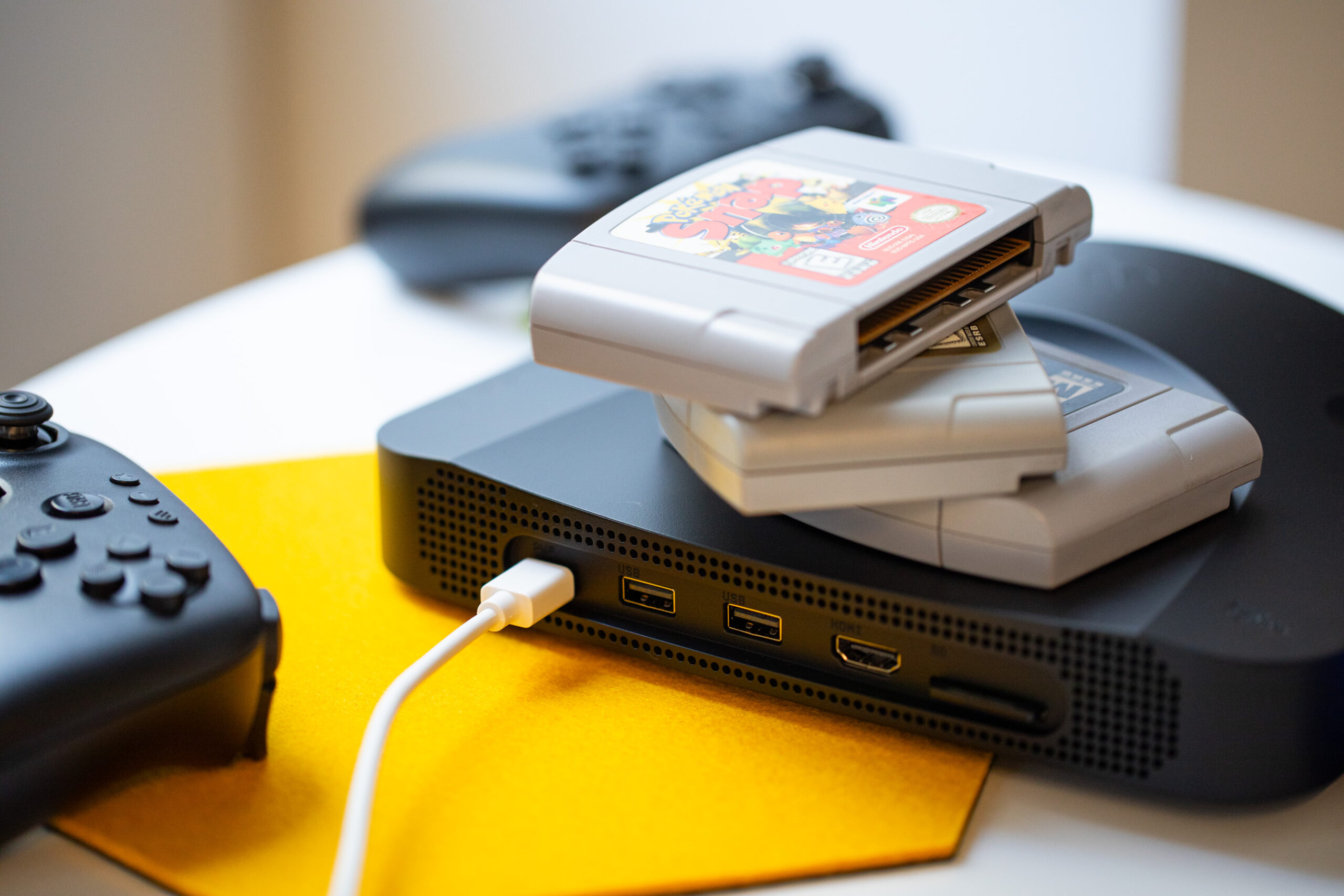 Several N64 cartridges stacked on top of the Analogue 3D console.
