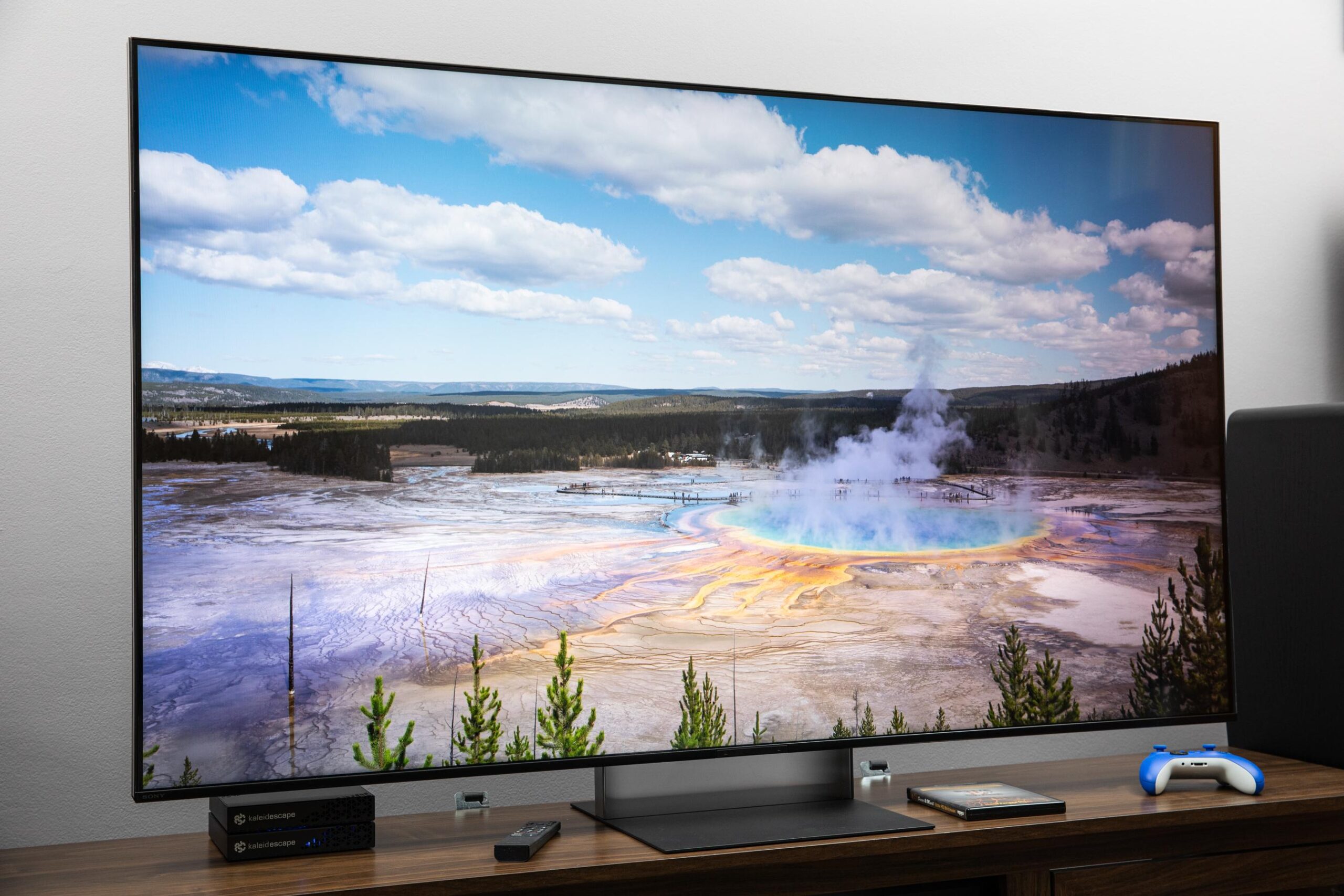 The Sony Bravia 7 II RGB LED TV on a dark wooden credenza displaying an image of hot springs.