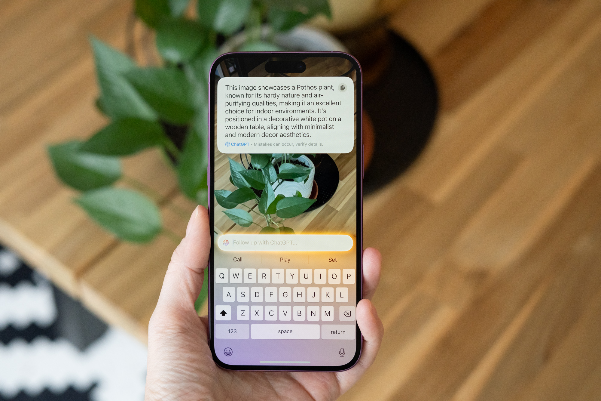 Photo of a hand holding iPhone with new Siri and ChatGPT.