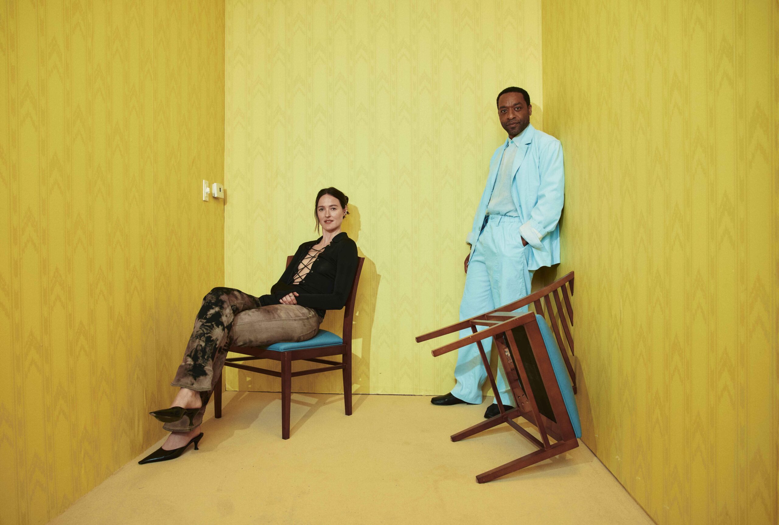 Chiwetel Ejiofor and Renate Reinsve in a yellow wallpapered backroom.