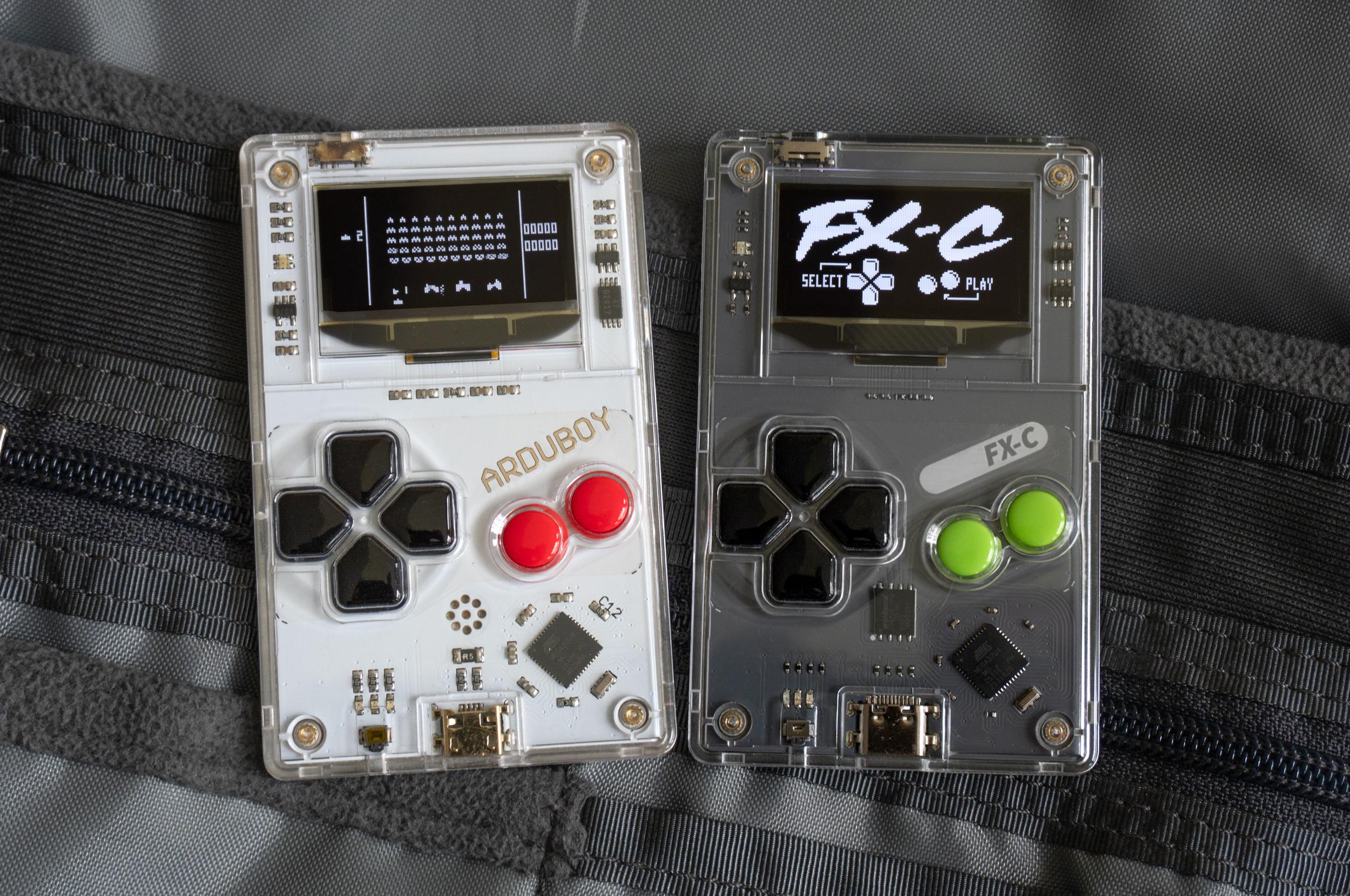 The original Arduboy next to the new Arduboy FX-C sitting on a backpack’s internal pockets. The original Arduboy next to the new Arduboy FX-C sitting on a backpack’s internal pockets.