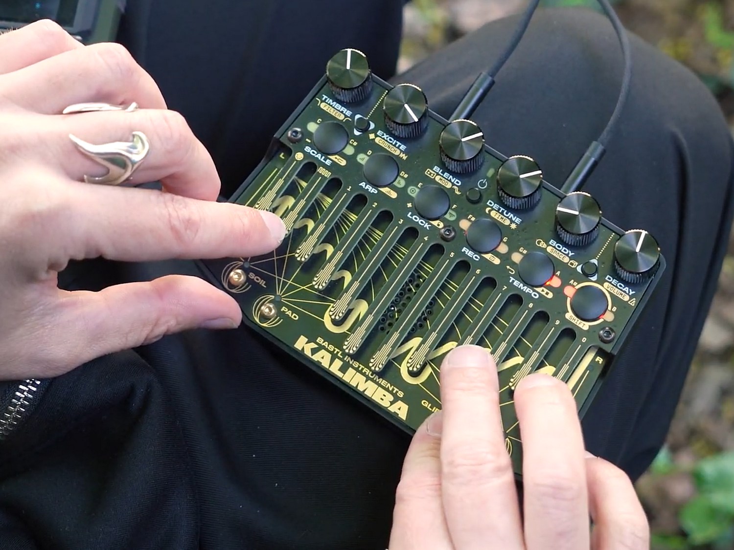 Bast Kalimba, a synth in the form factor of a thumb piano, being played outdoors.