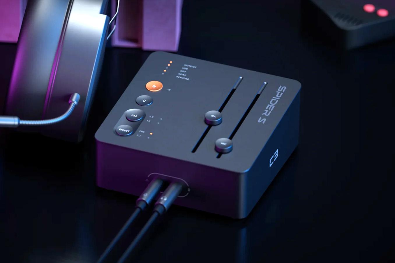 The Fosi Audio C3 Gaming Sound Card with cables connected next to a pair of headphones.