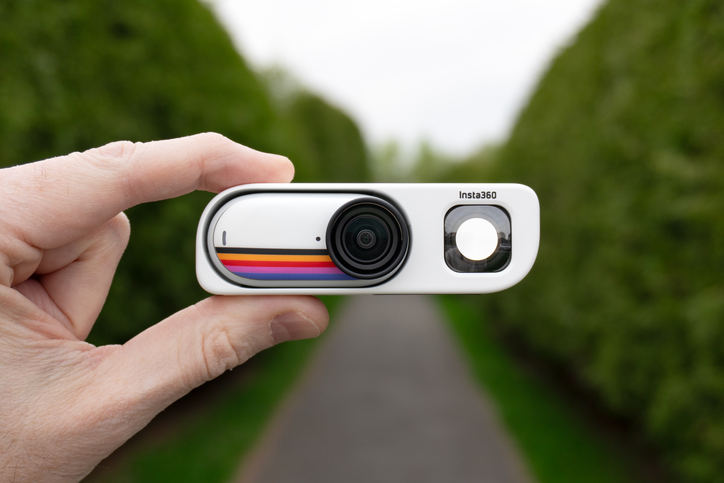 A person holds the Insta360 Retro Viewfinder with a Go 3S action camera inserted.