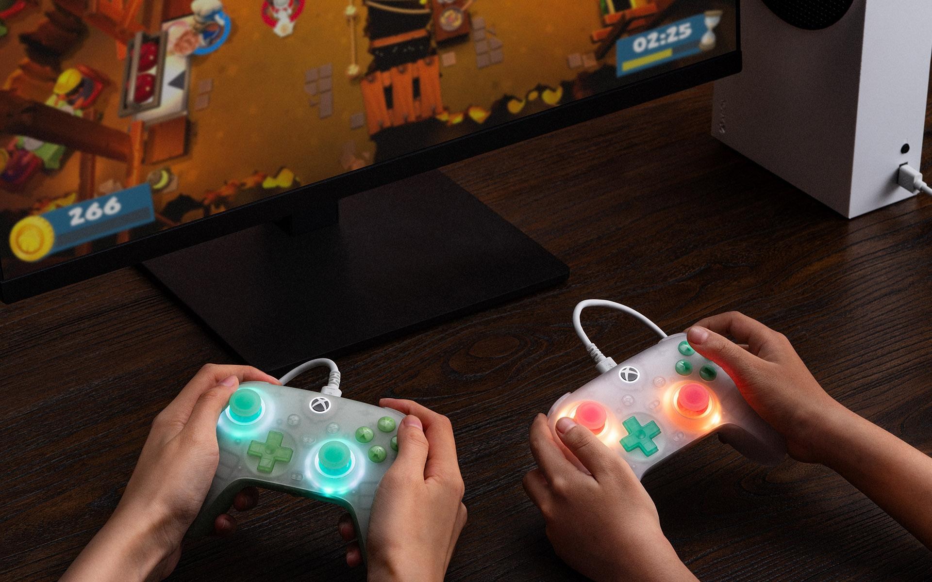 Two sets of hands playing games on 8BitDo Ultimate Mini Wired Controllers.