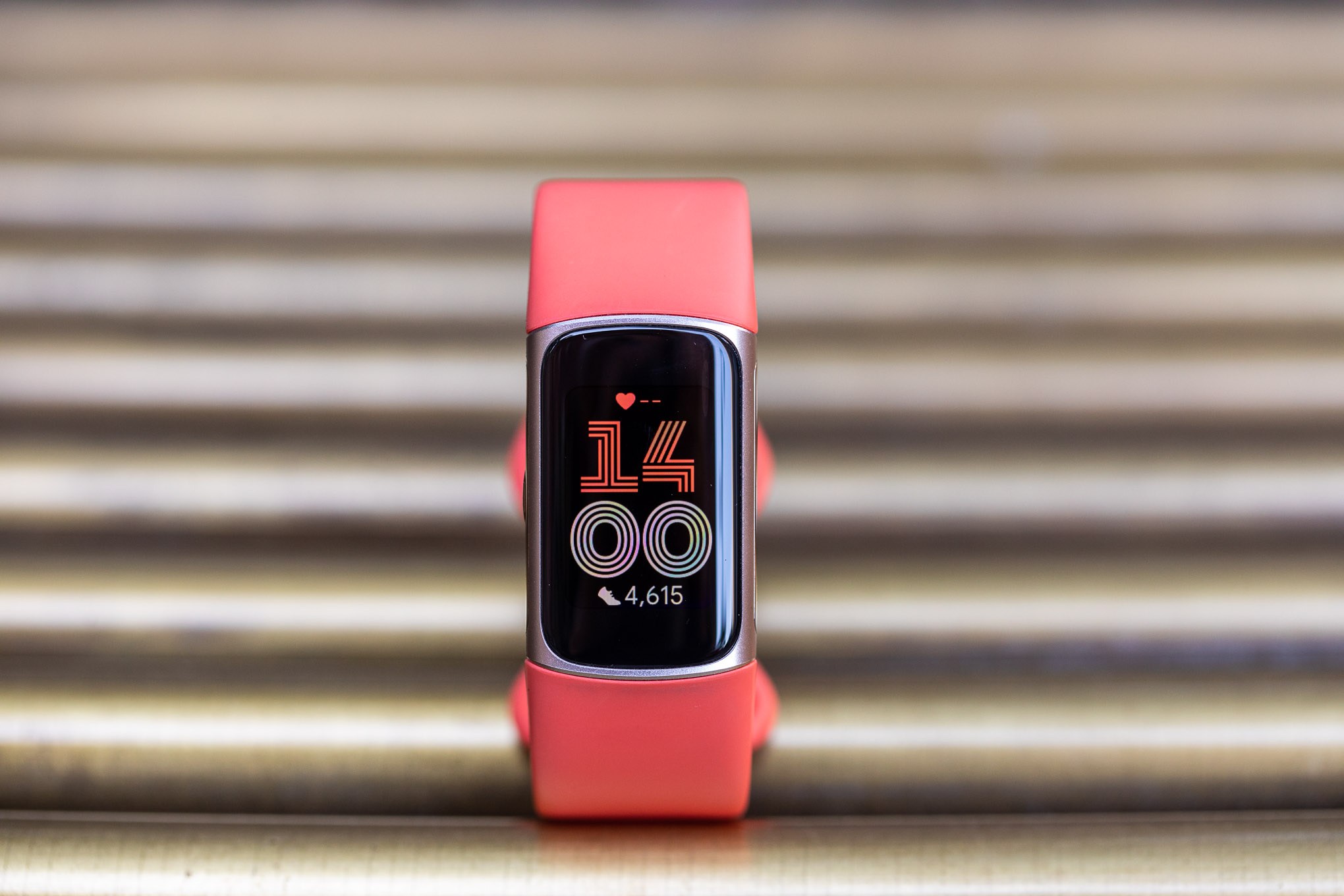 Front view of the coral and gold Fitbit Charge 6
