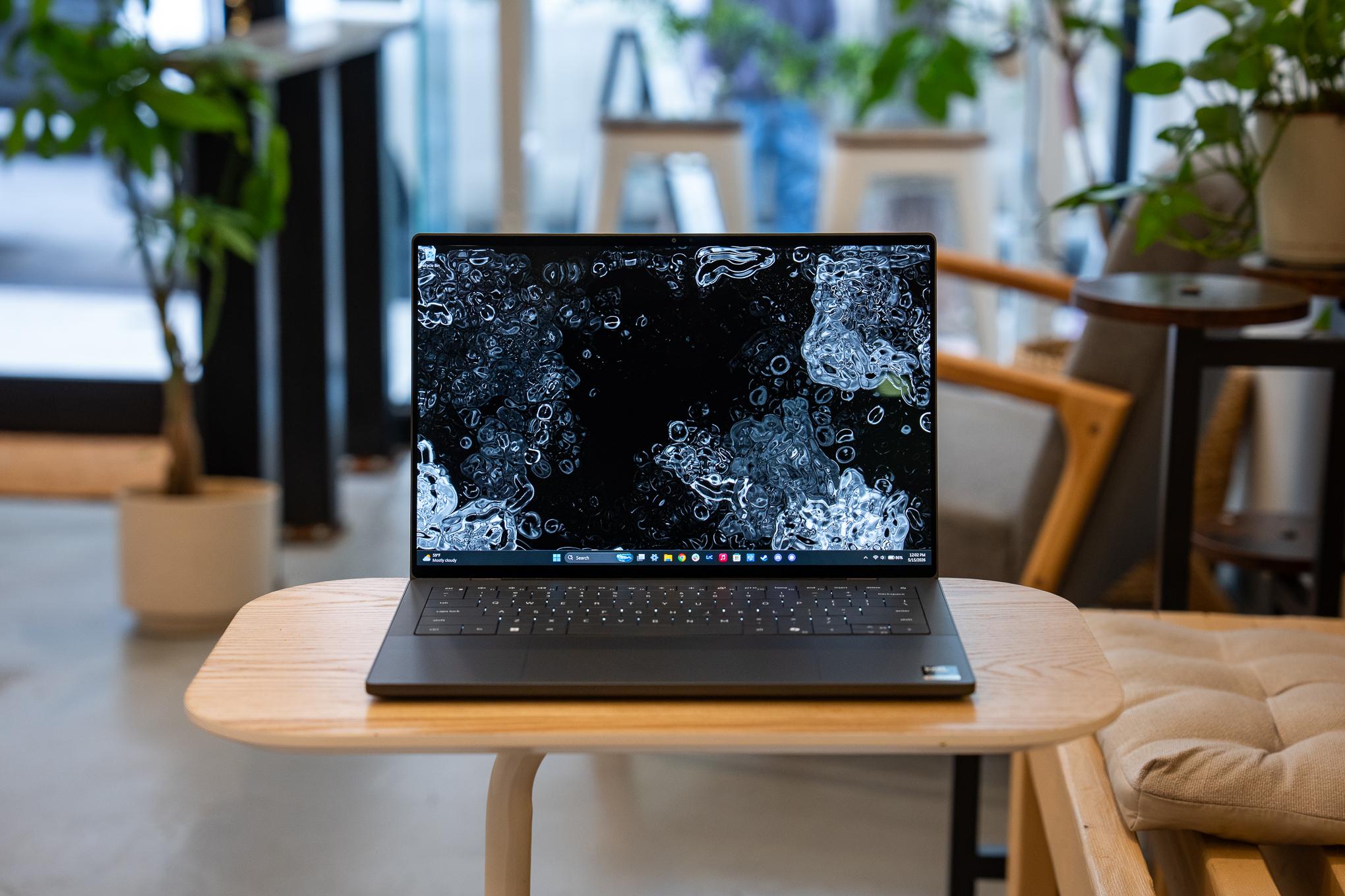 The 2026 Dell XPS 14 sitting on a small table in a cafe.