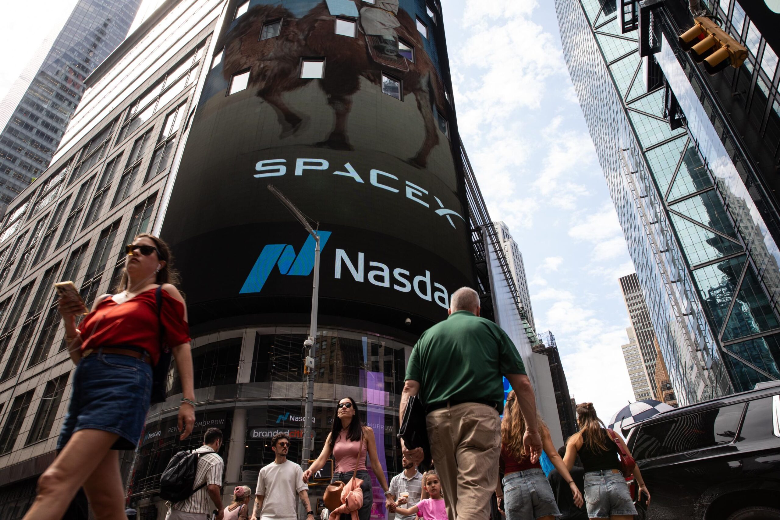 People walking by in front of the Nasdaq building on the day of the SpaceX IPO.