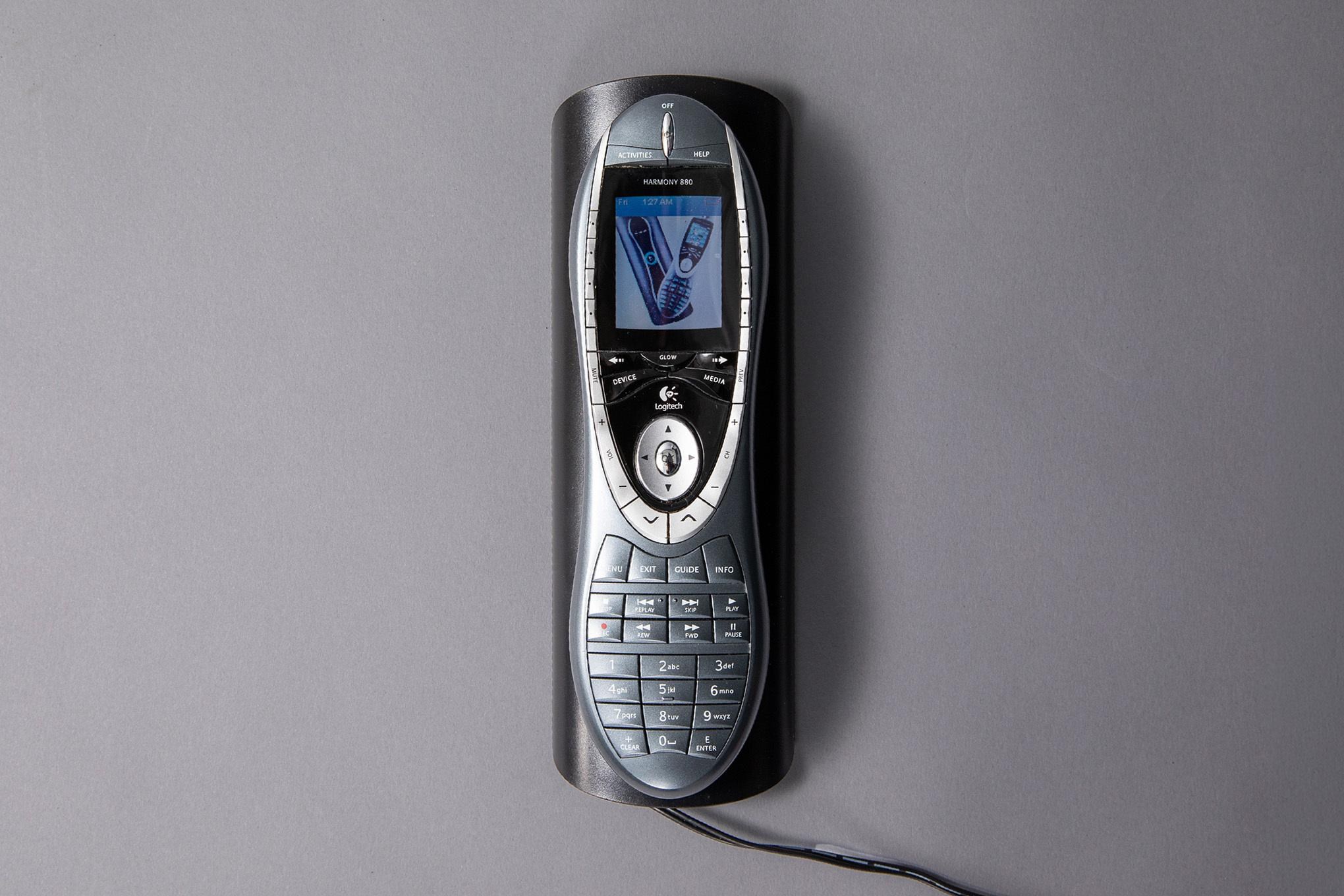 A photo of a silver remote, on its charging cradle.