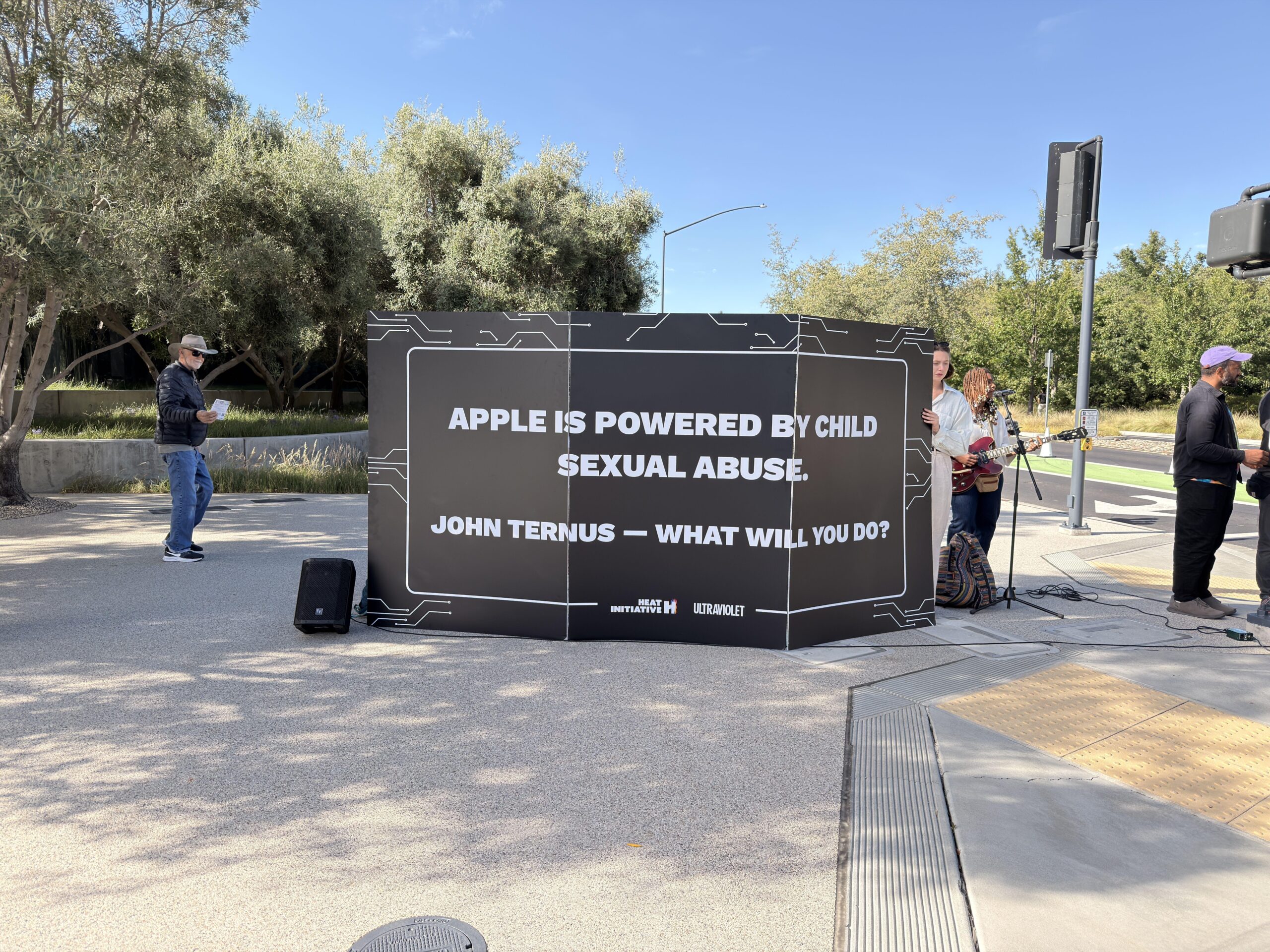 A protest sign that reads, “Apple is powered by child sexual abuse. John Ternus — what will you do?”
